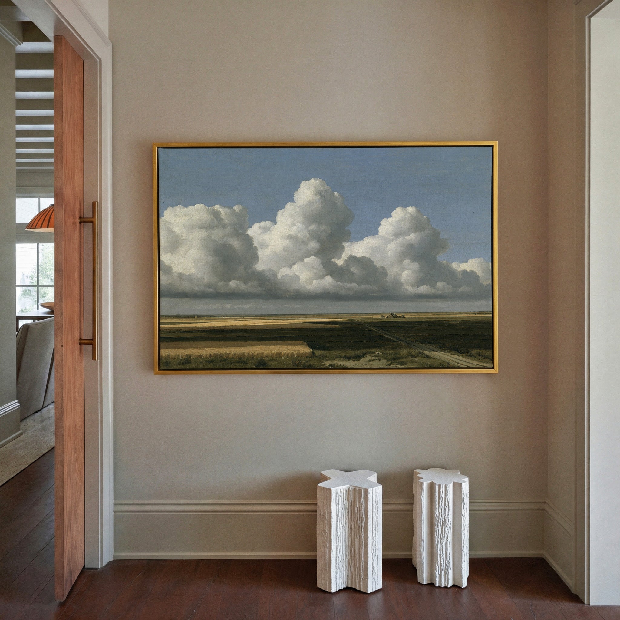 vast blue sky over low patchwork fields canvas wall art in a gold frame in a styled room setting