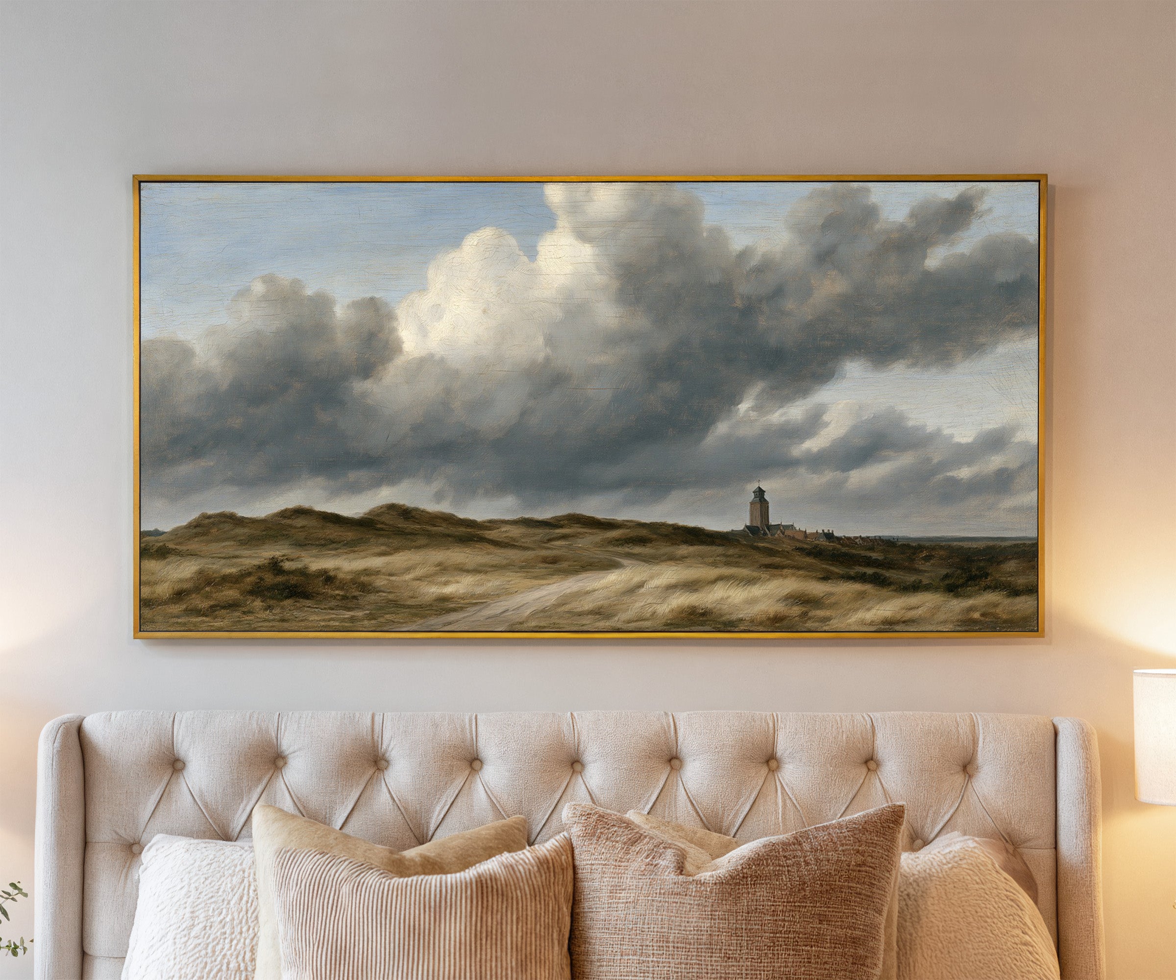 low dunes under towering wind driven clouds canvas wall art in a gold frame above a bed