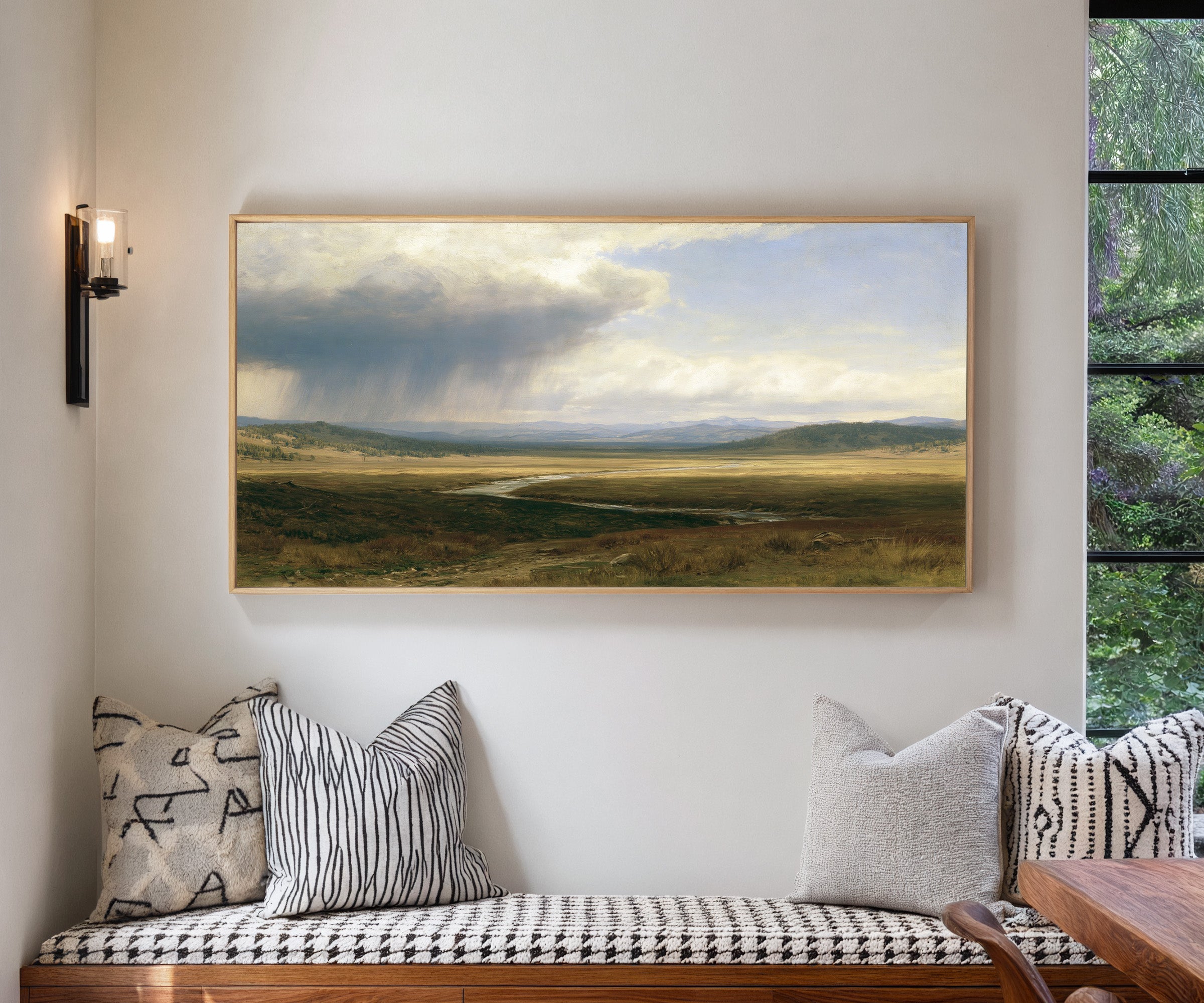 broad plain under a split storm sky canvas wall art in a natural wood frame in a living room