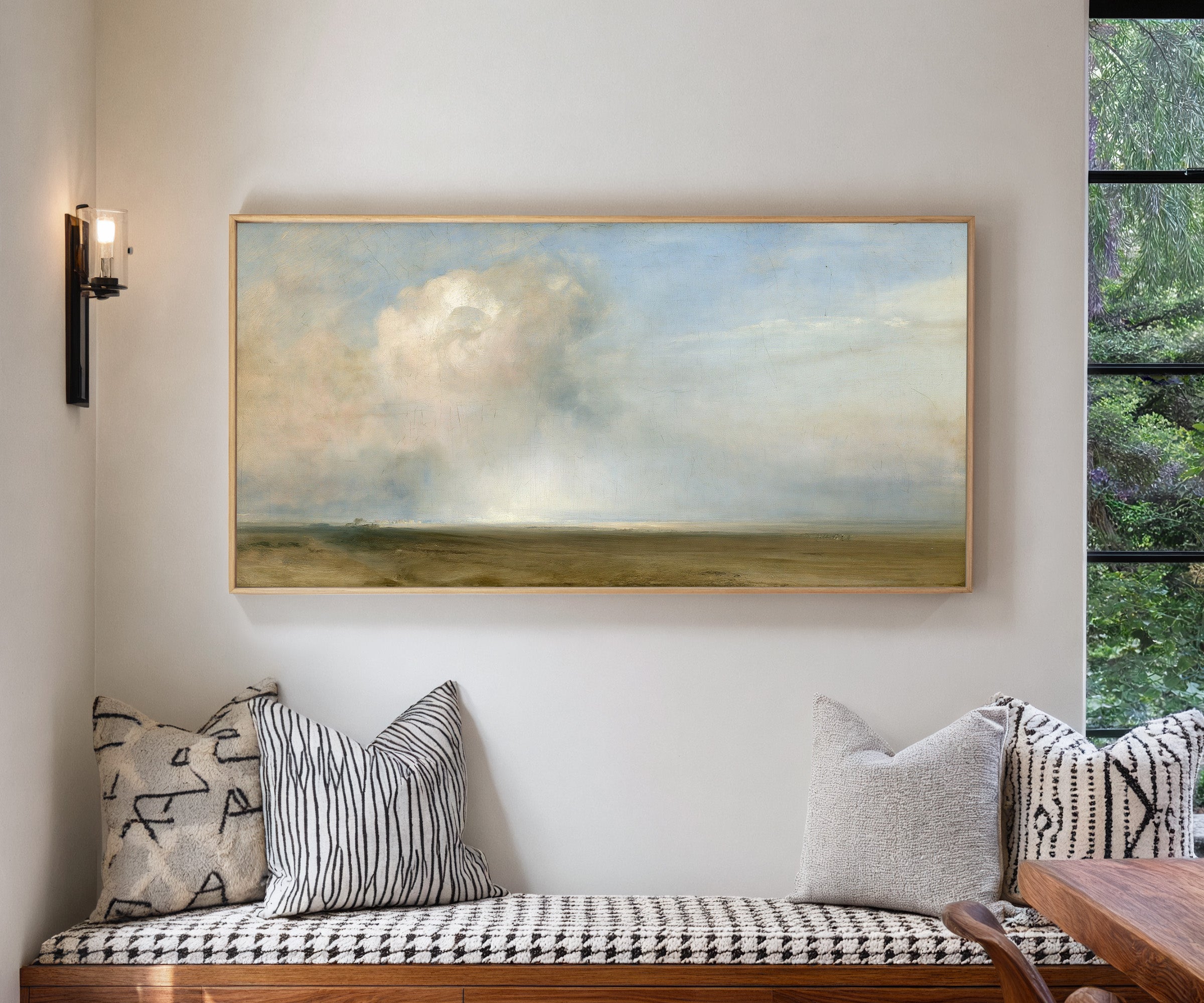 single towering cumulus cloud over a low plain canvas wall art in a natural wood frame in a living room