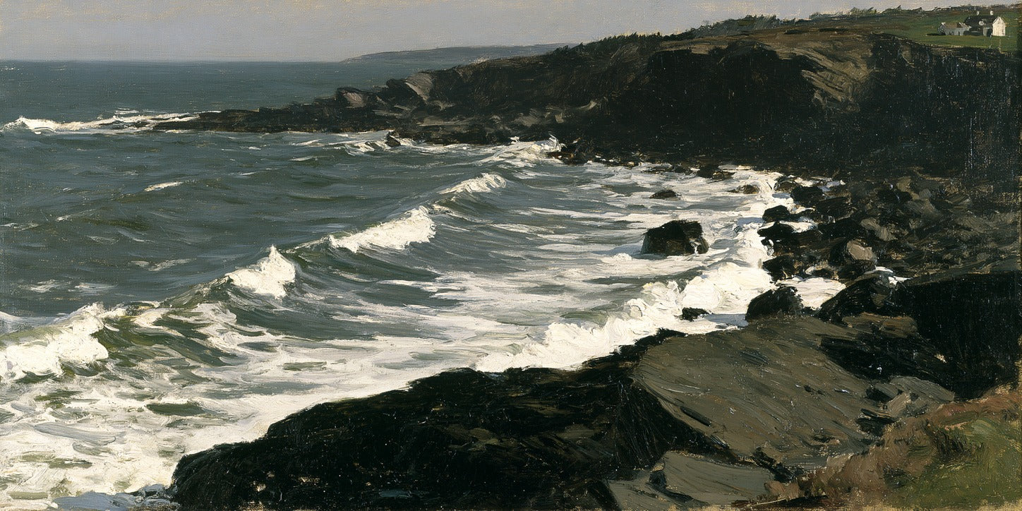 Diagonal white surf breaks against dark rocks along a slate-green rocky coastline