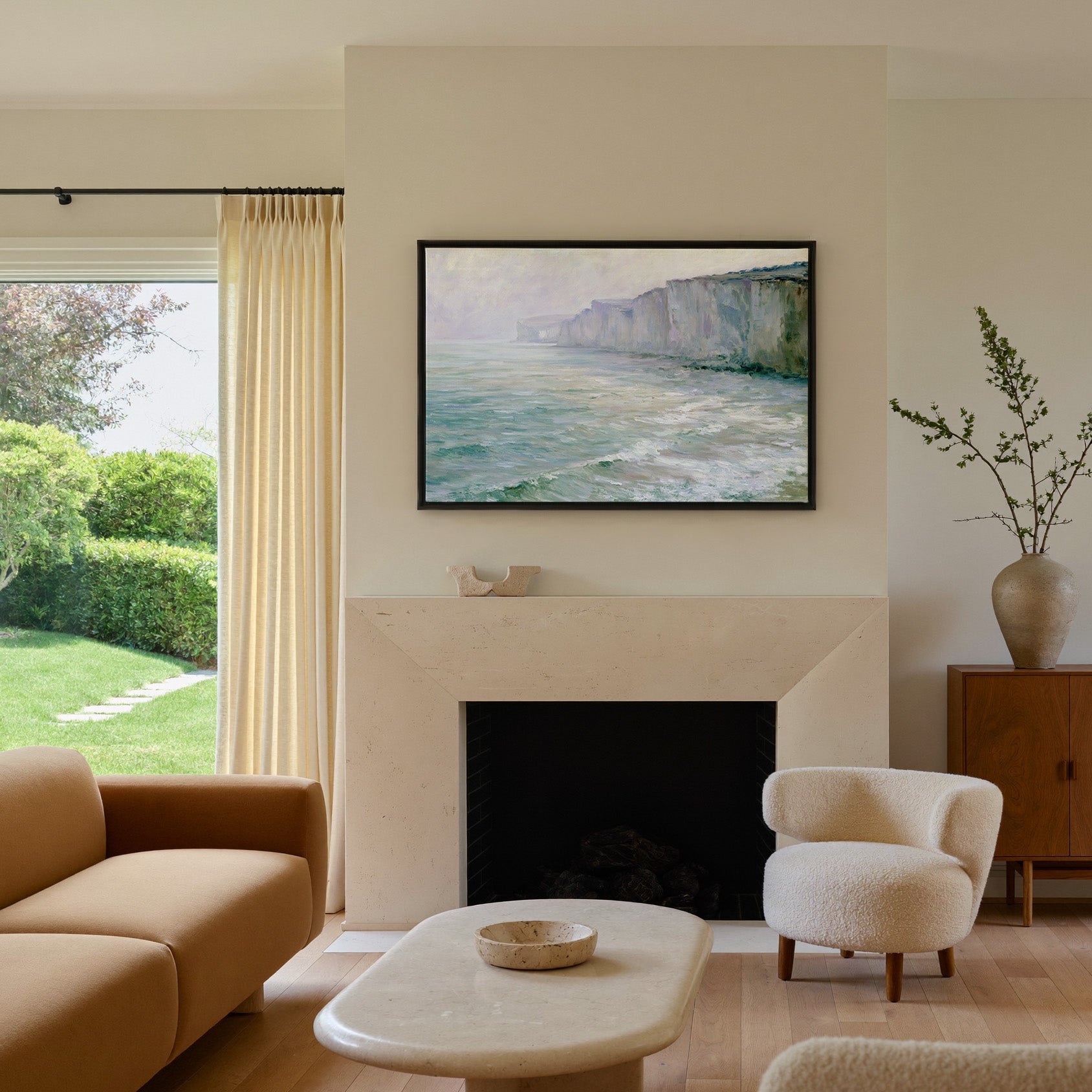 soft chalk cliffs above pale green sea canvas wall art in a black frame above a mantel