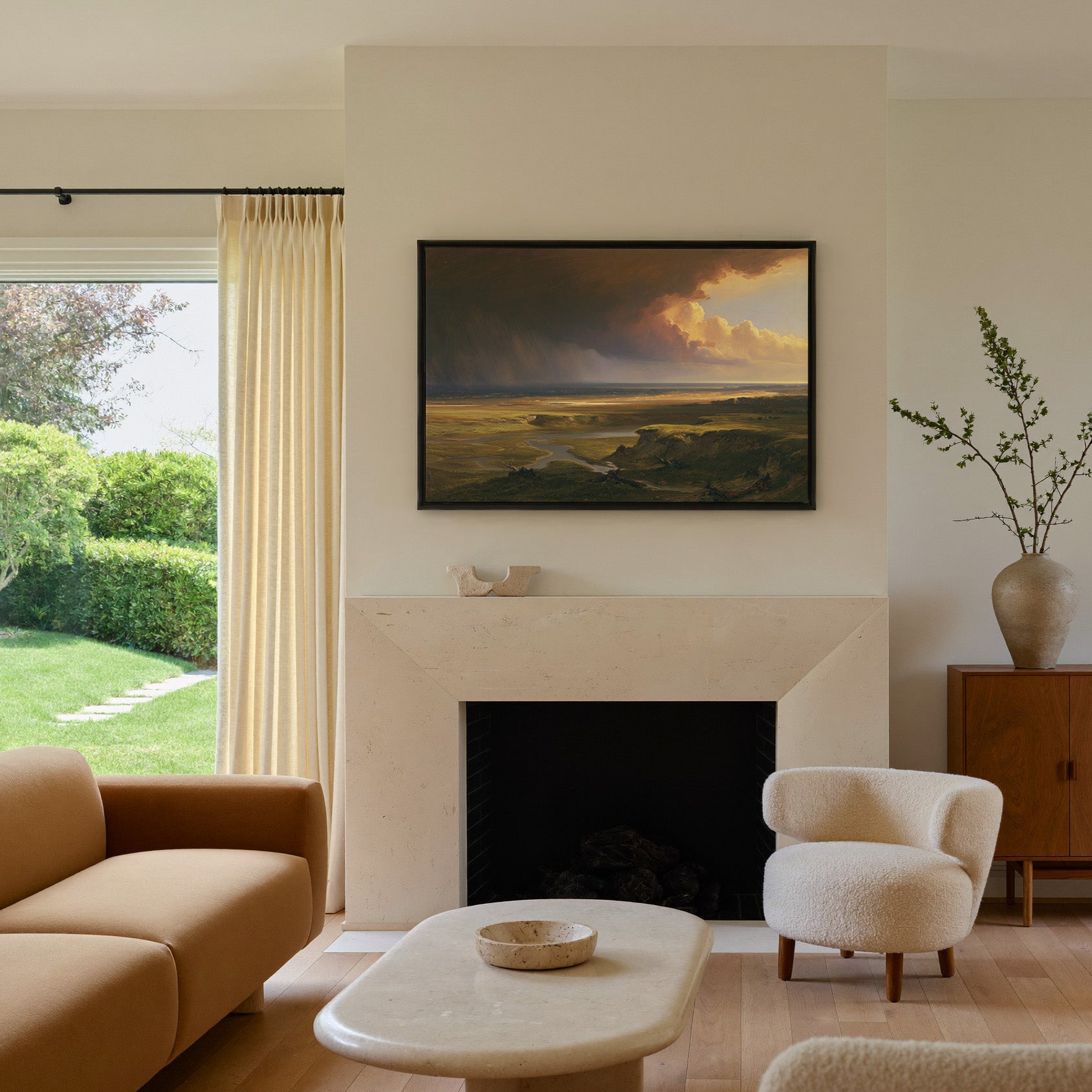 storm light over a broad coastal plain canvas wall art in a black frame above a mantel
