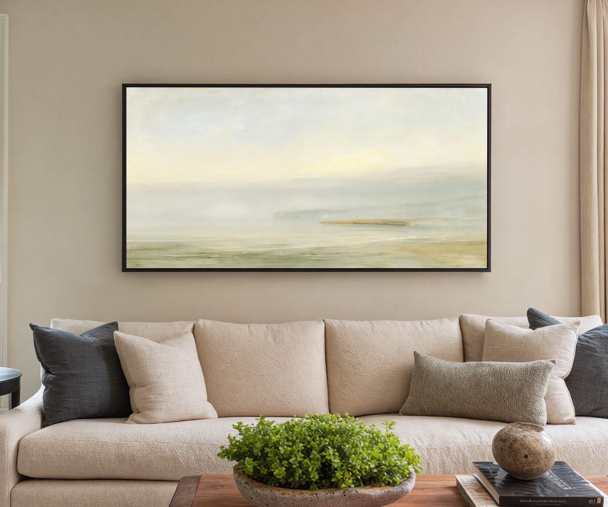 pale sea with a faint distant headland canvas wall art in a black frame in a styled room setting