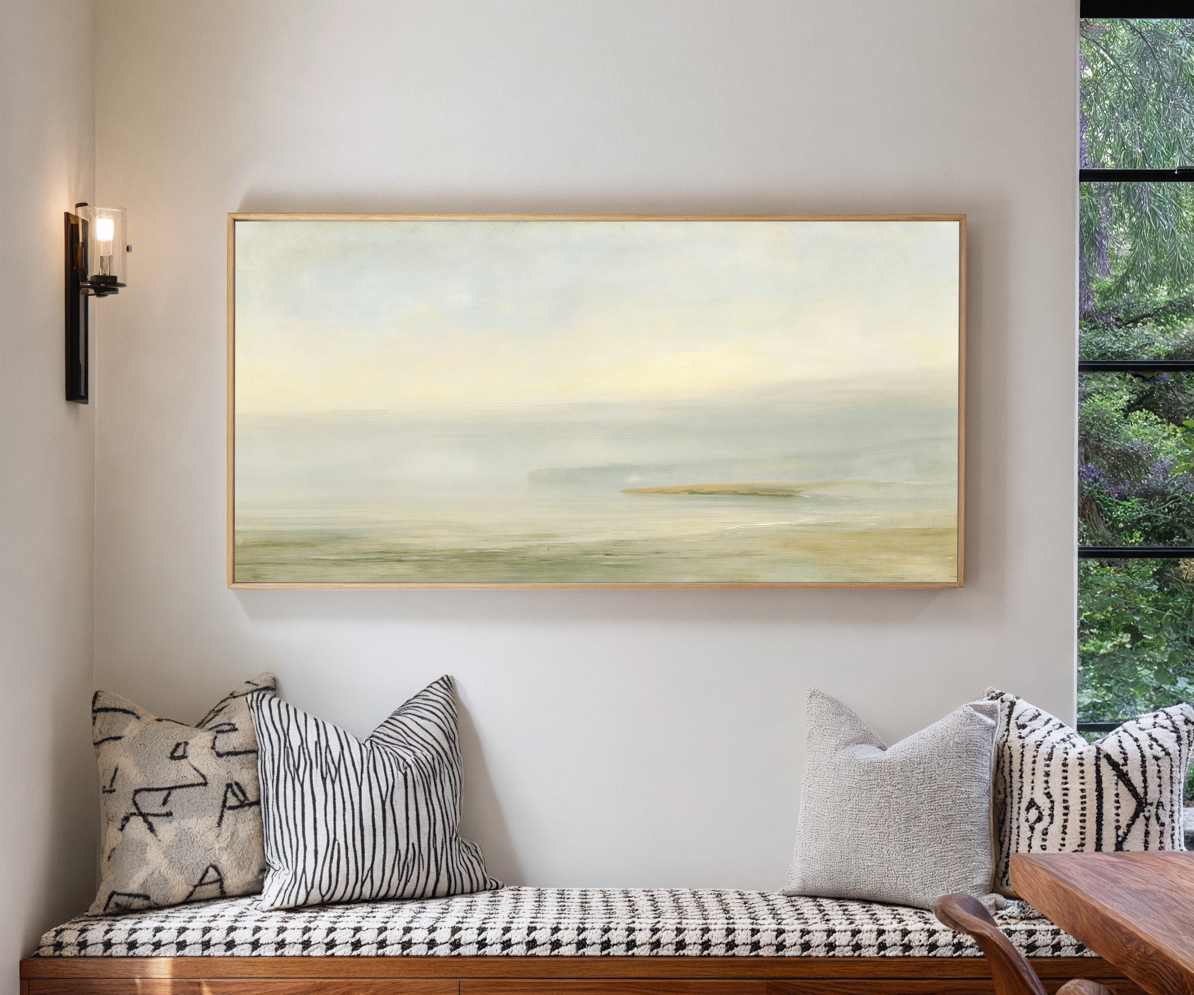 pale sea with a faint distant headland canvas wall art in a natural wood frame in a living room