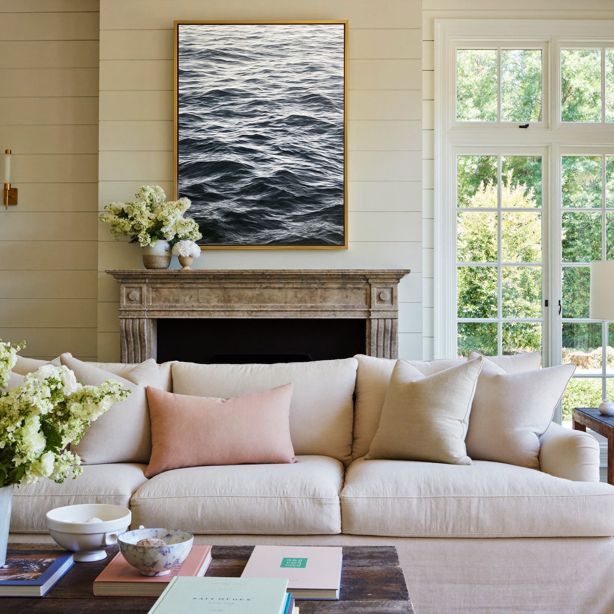 dark rippling ocean water canvas wall art in a gold frame above a mantel