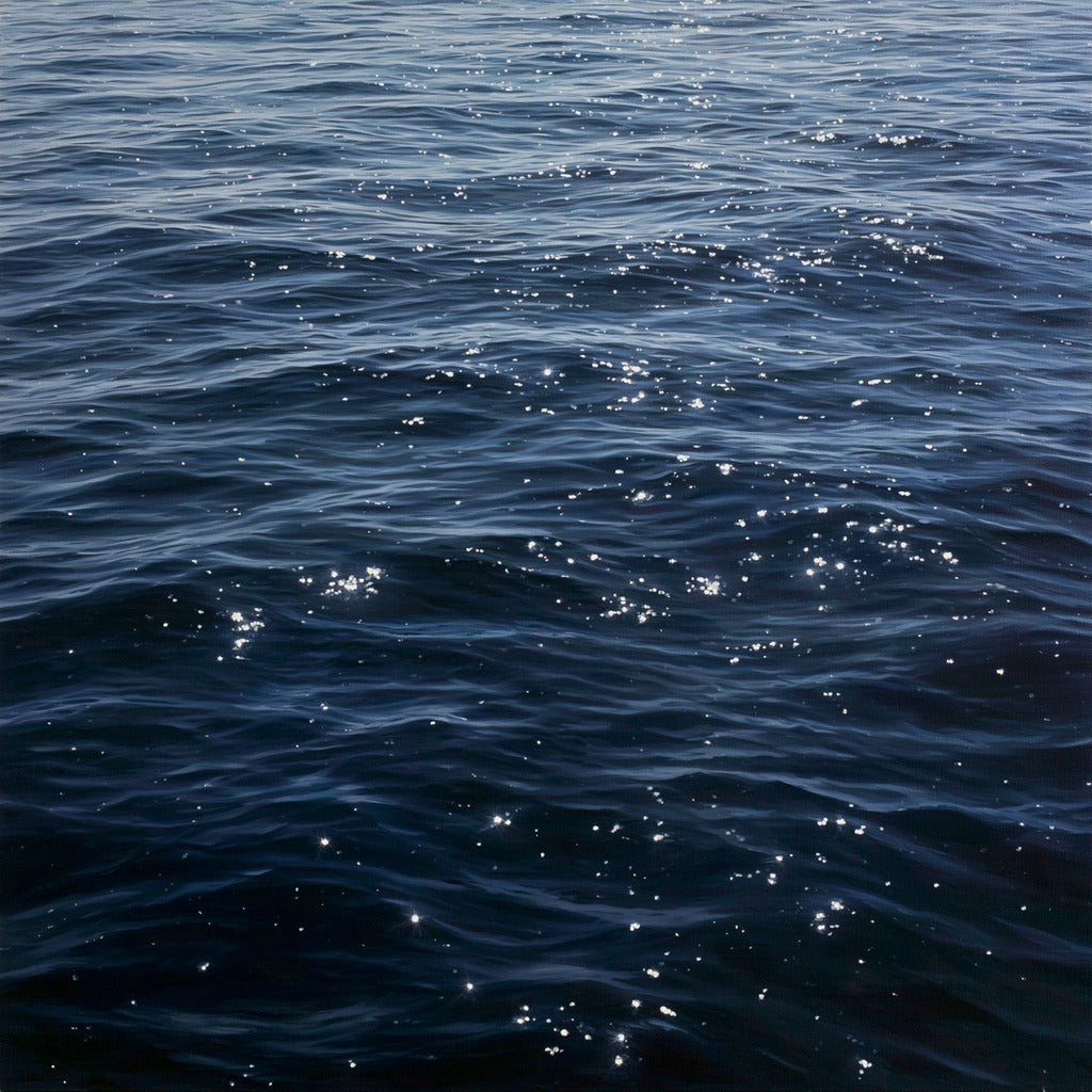 Dark blue ocean water with scattered white reflections and layered ripples