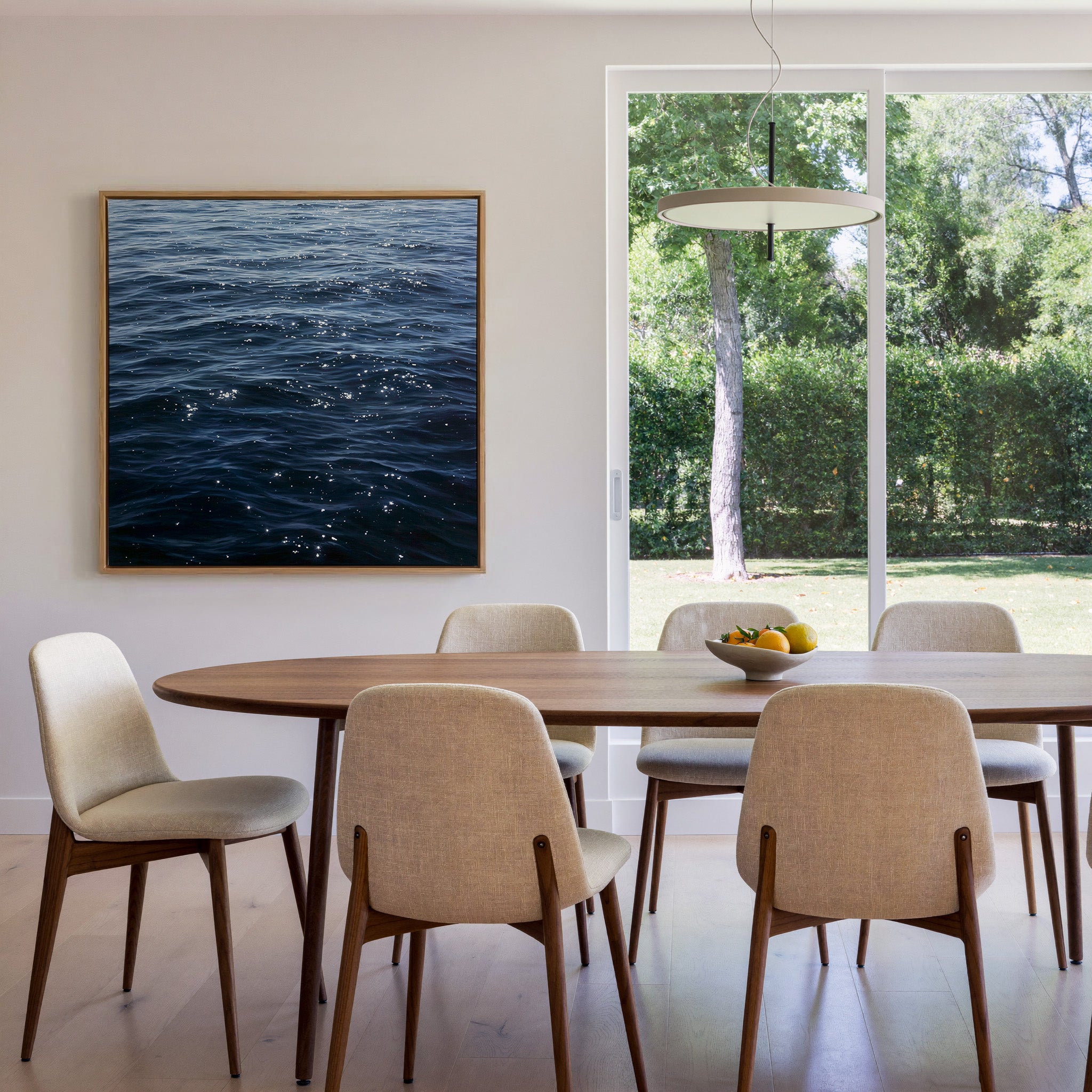 dark blue water with scattered white reflections canvas wall art in an oak frame in a dining room