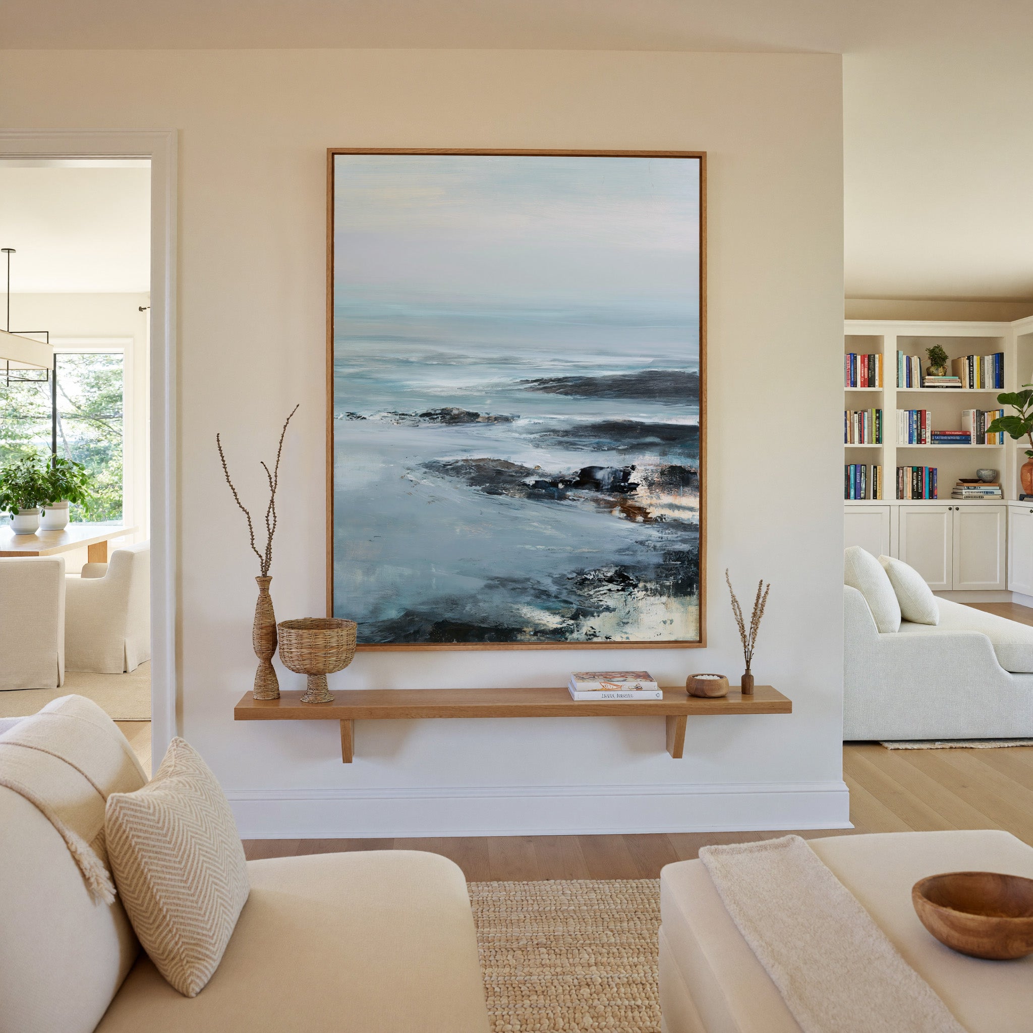 cold northern sea with pale sky and dark rock canvas wall art in an oak frame in a living room