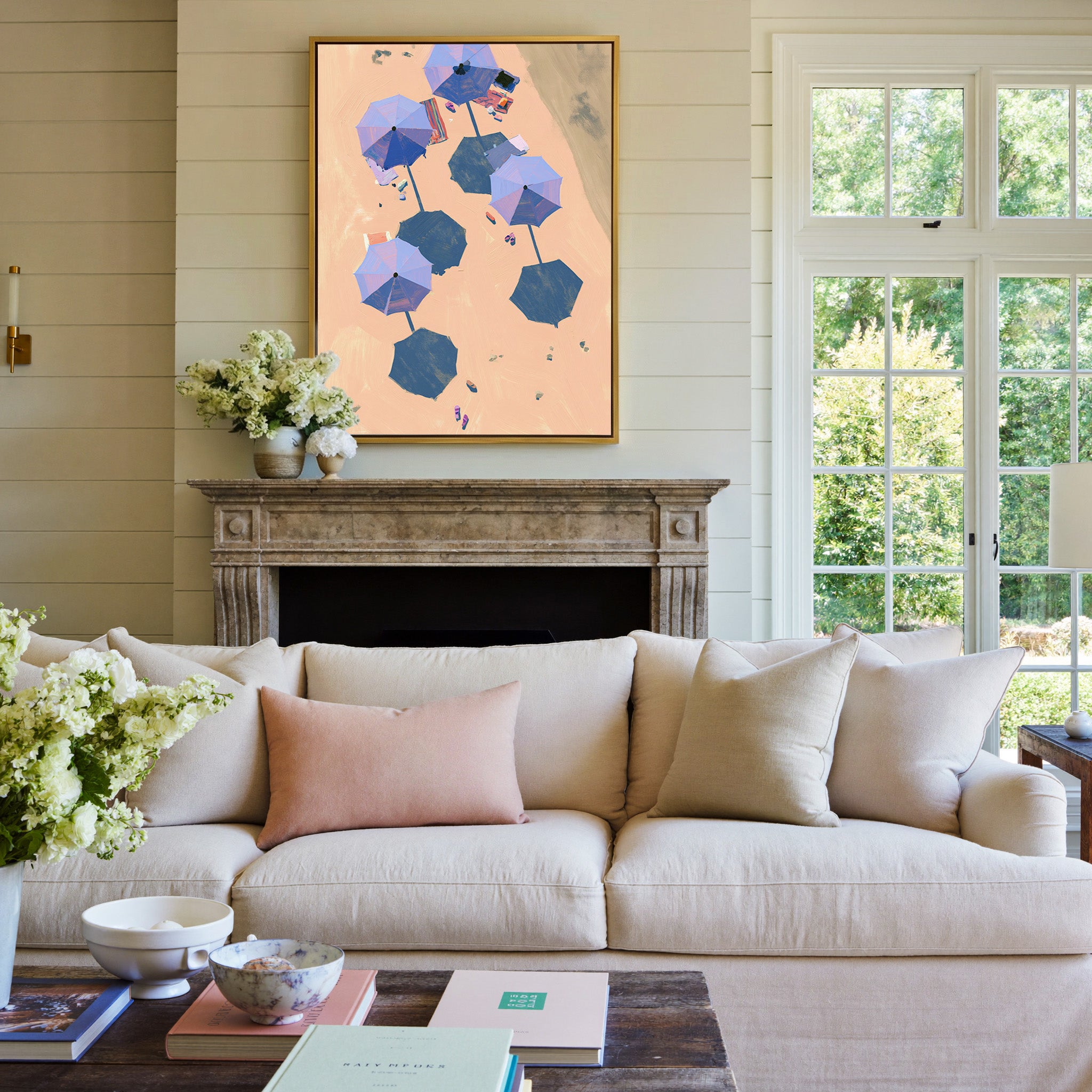 overhead beach umbrellas on peach sand canvas wall art in a gold frame above a mantel