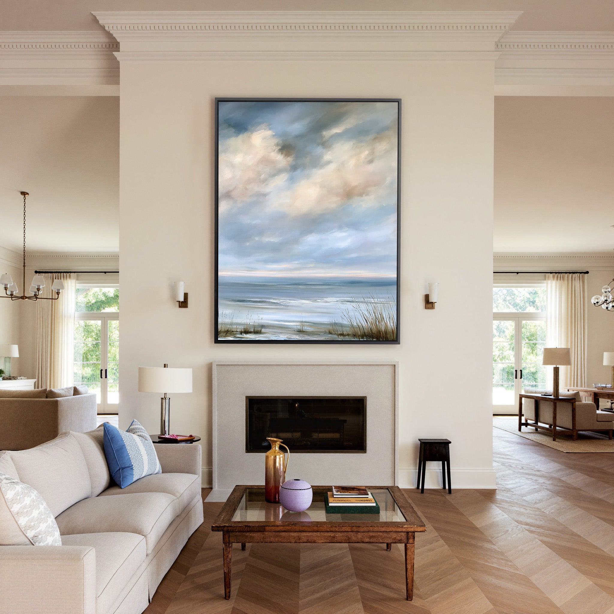 pale coastal horizon beneath broken clouds canvas wall art in a black frame above a mantel