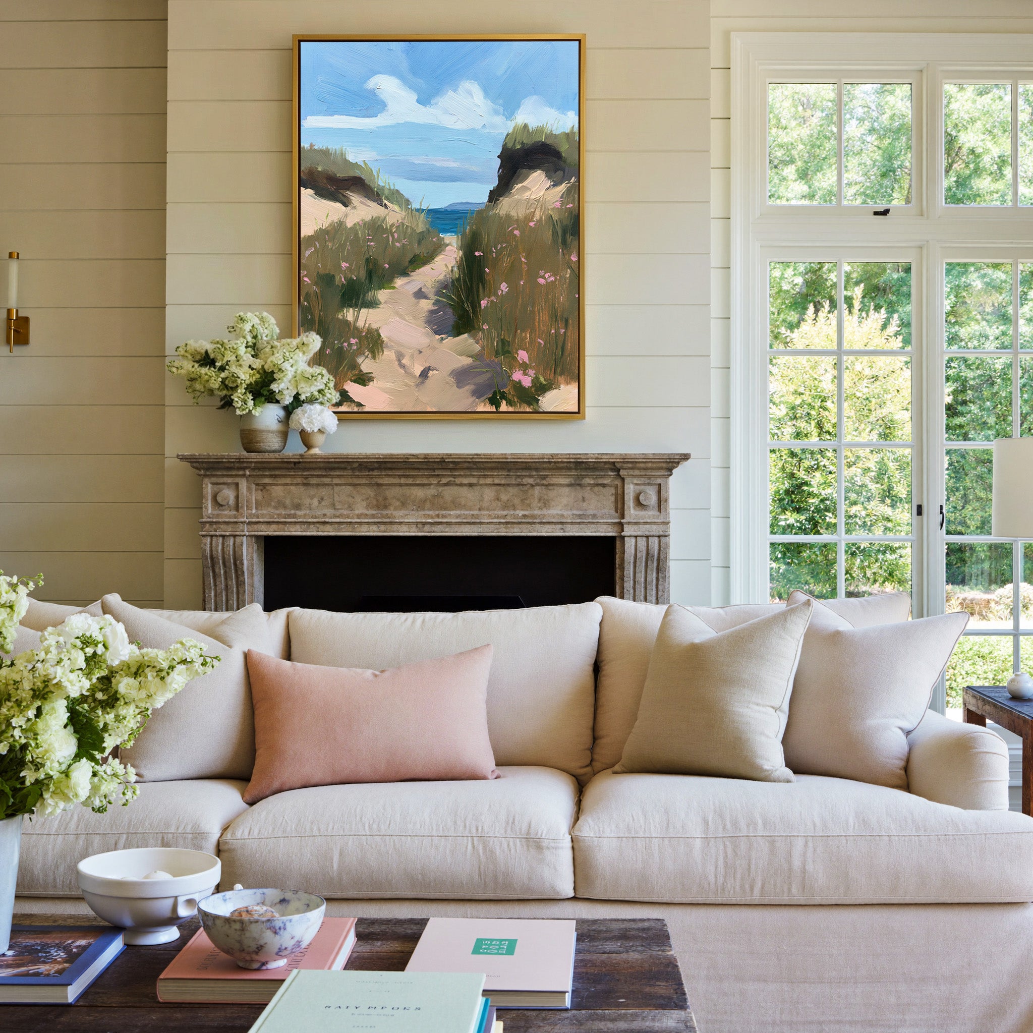 windswept coastal path with dune grass and pink canvas wall art in a gold frame above a mantel