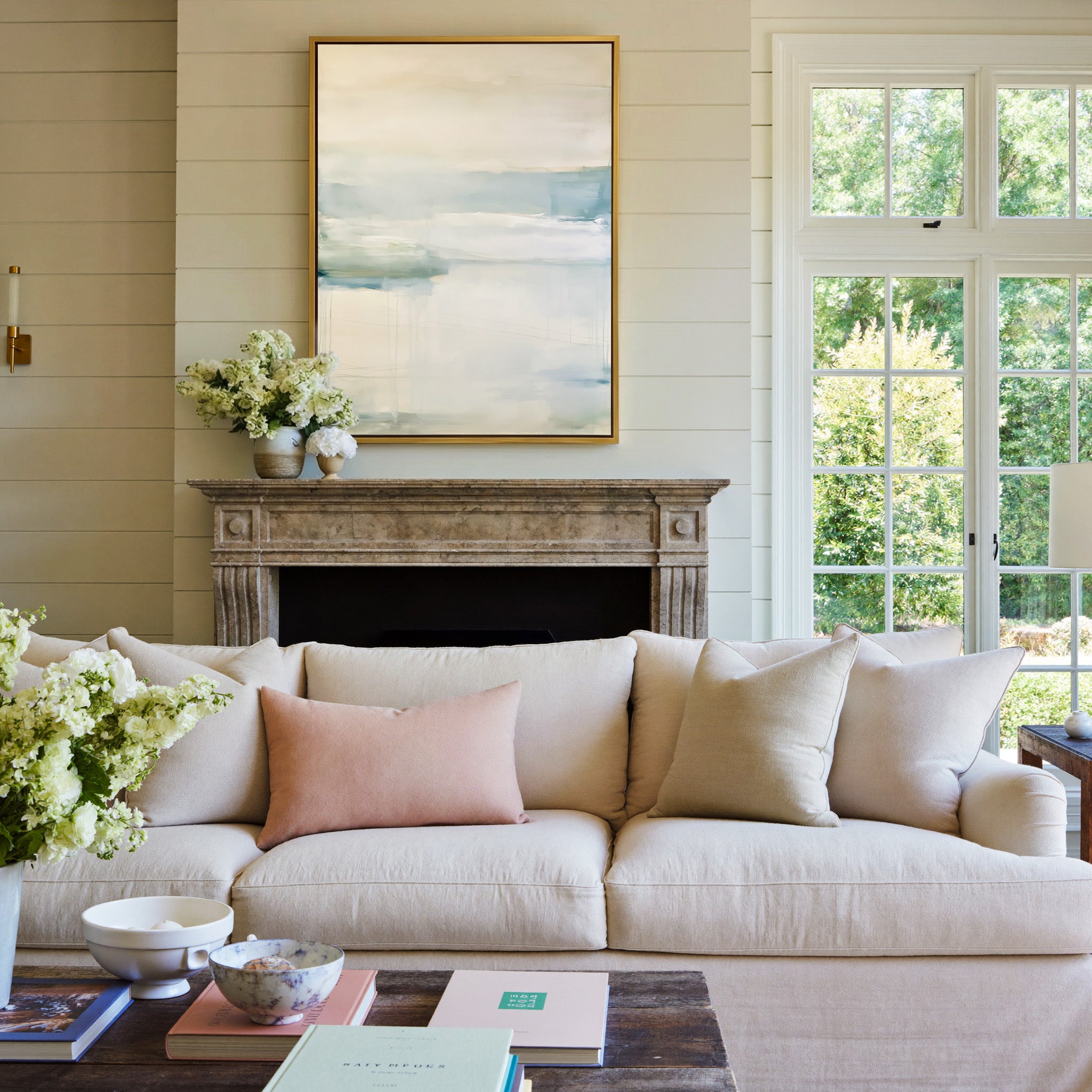 soft cream and blue abstract with misty canvas wall art in a gold frame above a mantel