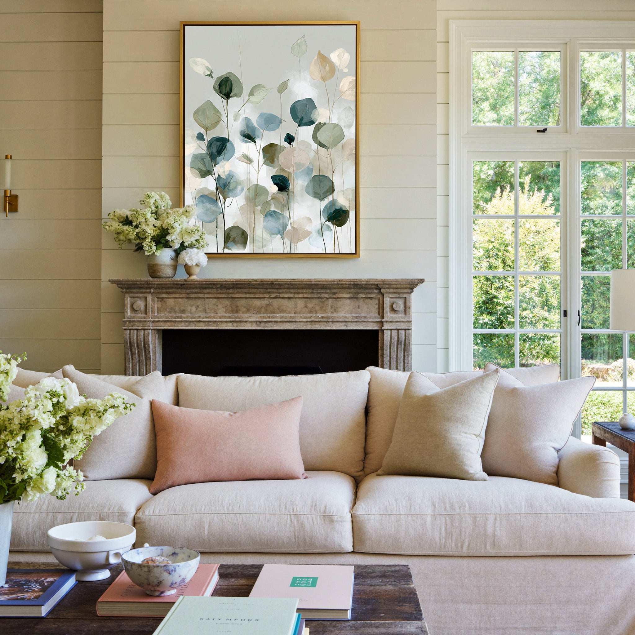 soft eucalyptus like leaves in muted green, canvas wall art in a gold frame above a mantel