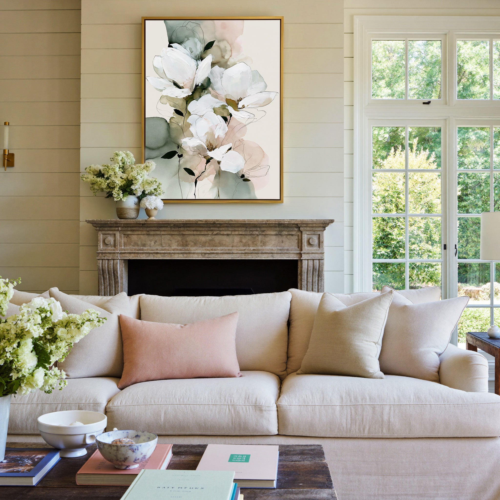 white magnolia like blooms with sage and blush canvas wall art in a gold frame above a mantel