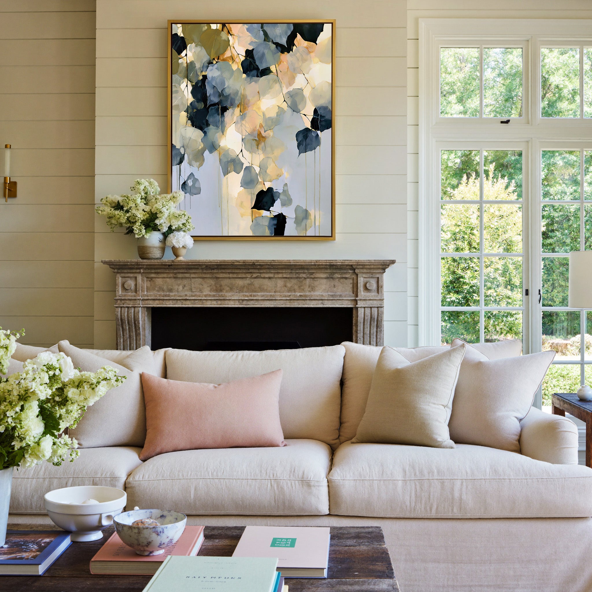 soft blue gray and gold abstract with hanging canvas wall art in a gold frame above a mantel