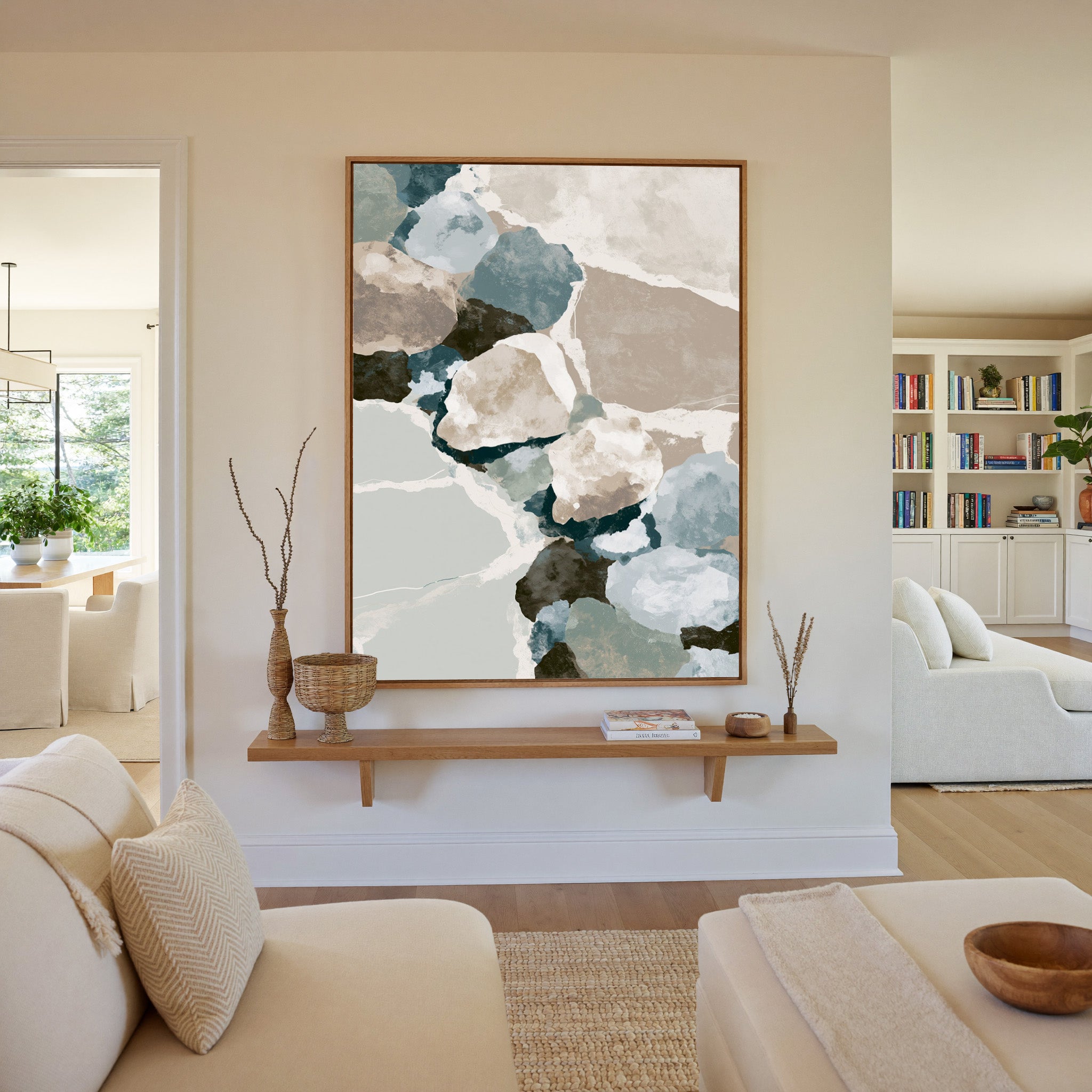 muted coastal abstract with oyster shell shapes canvas wall art in an oak frame in a living room