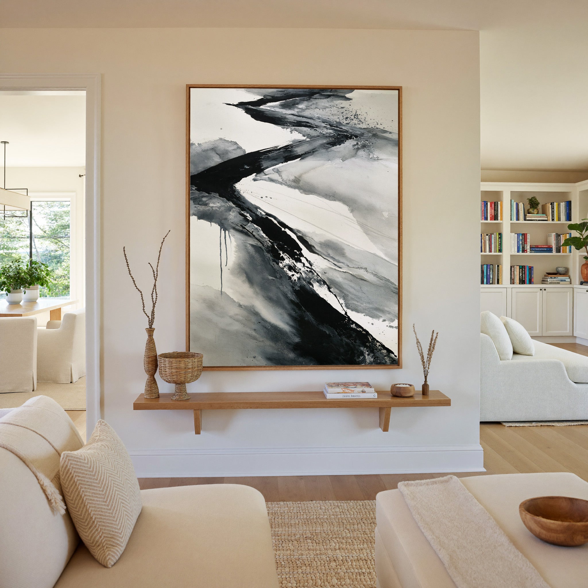 black and gray flowing abstract canvas wall art in an oak frame in a living room