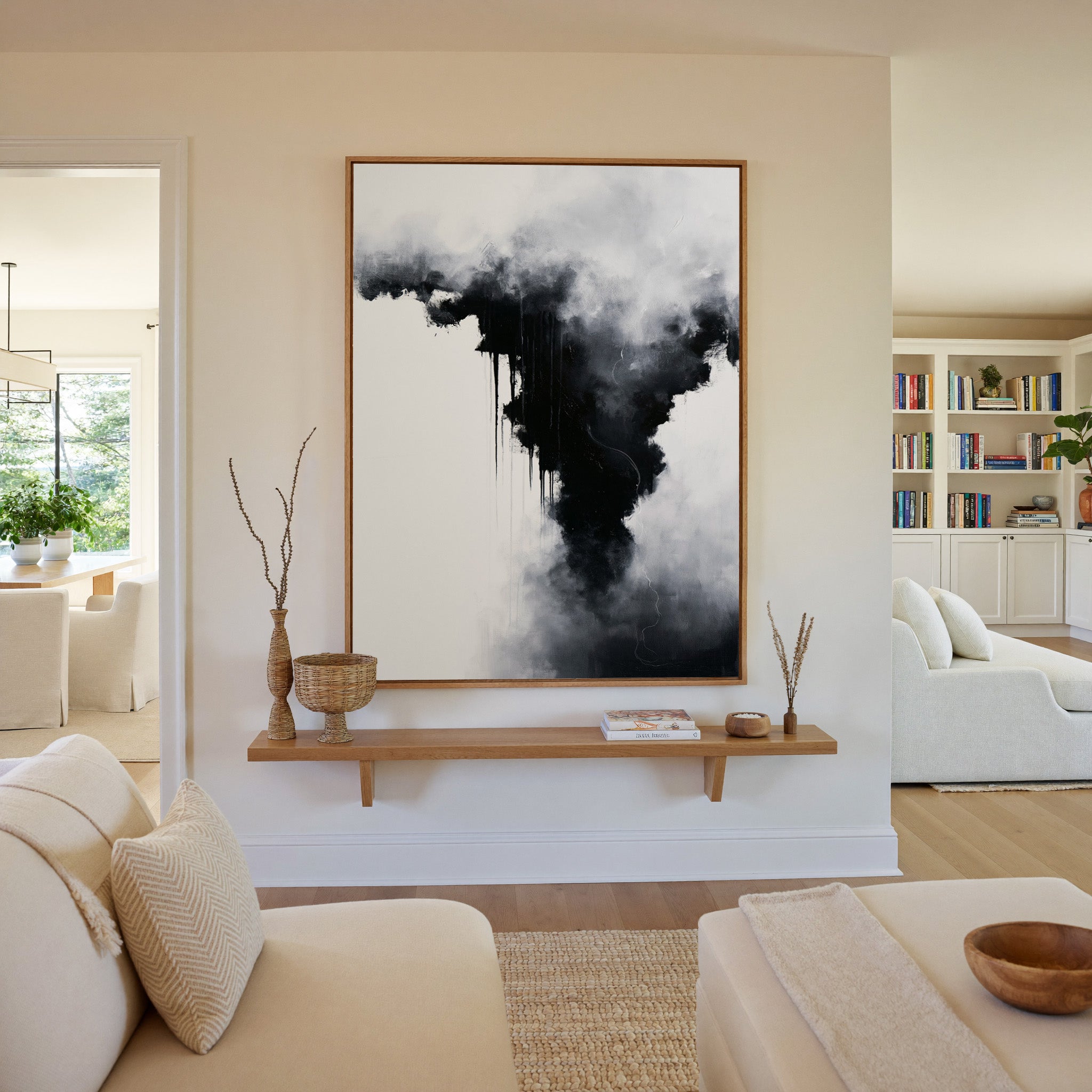 black and white abstract with smoky gray clouds canvas wall art in an oak frame in a living room