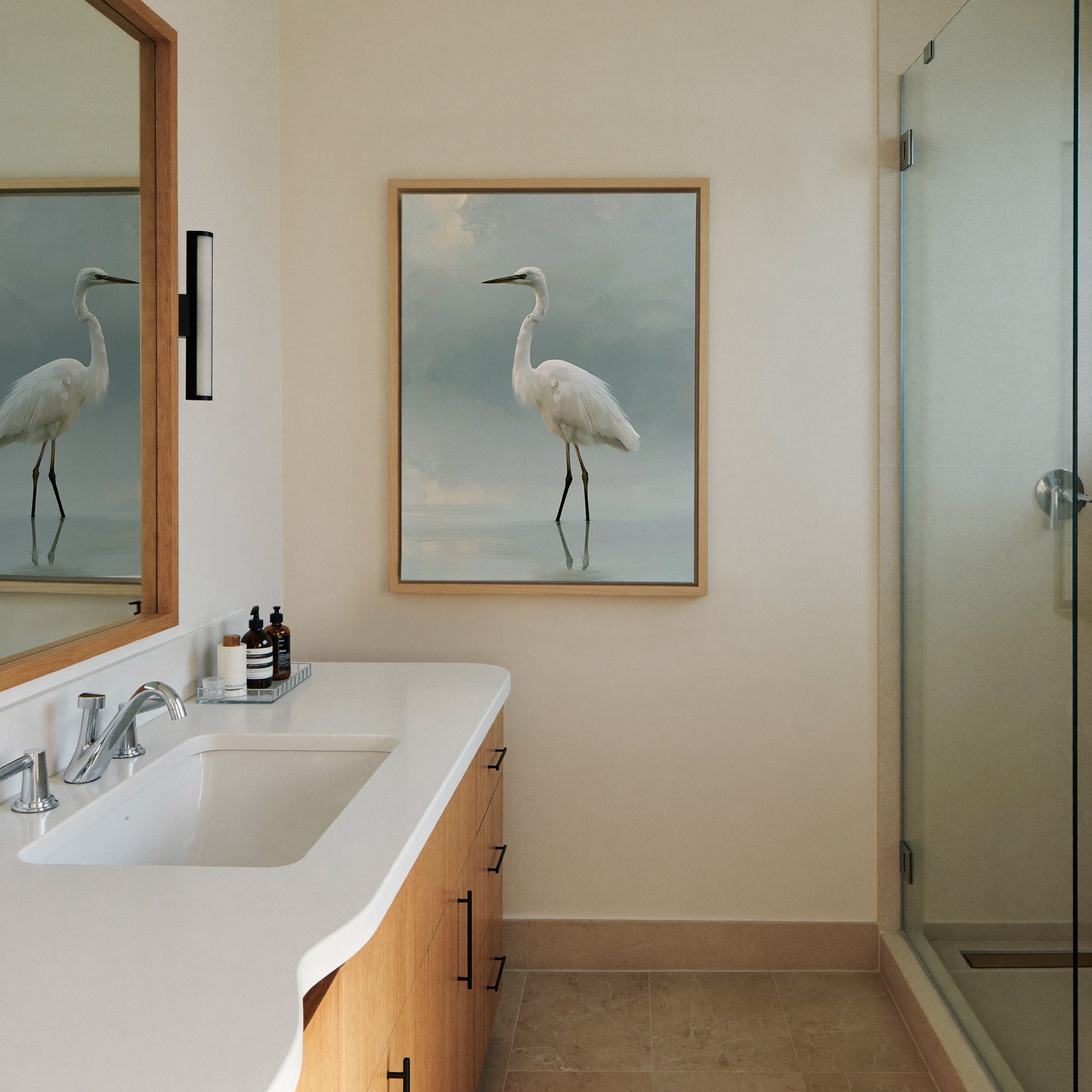 white heron standing in pale reflective water canvas wall art in a natural wood frame in a styled room setting
