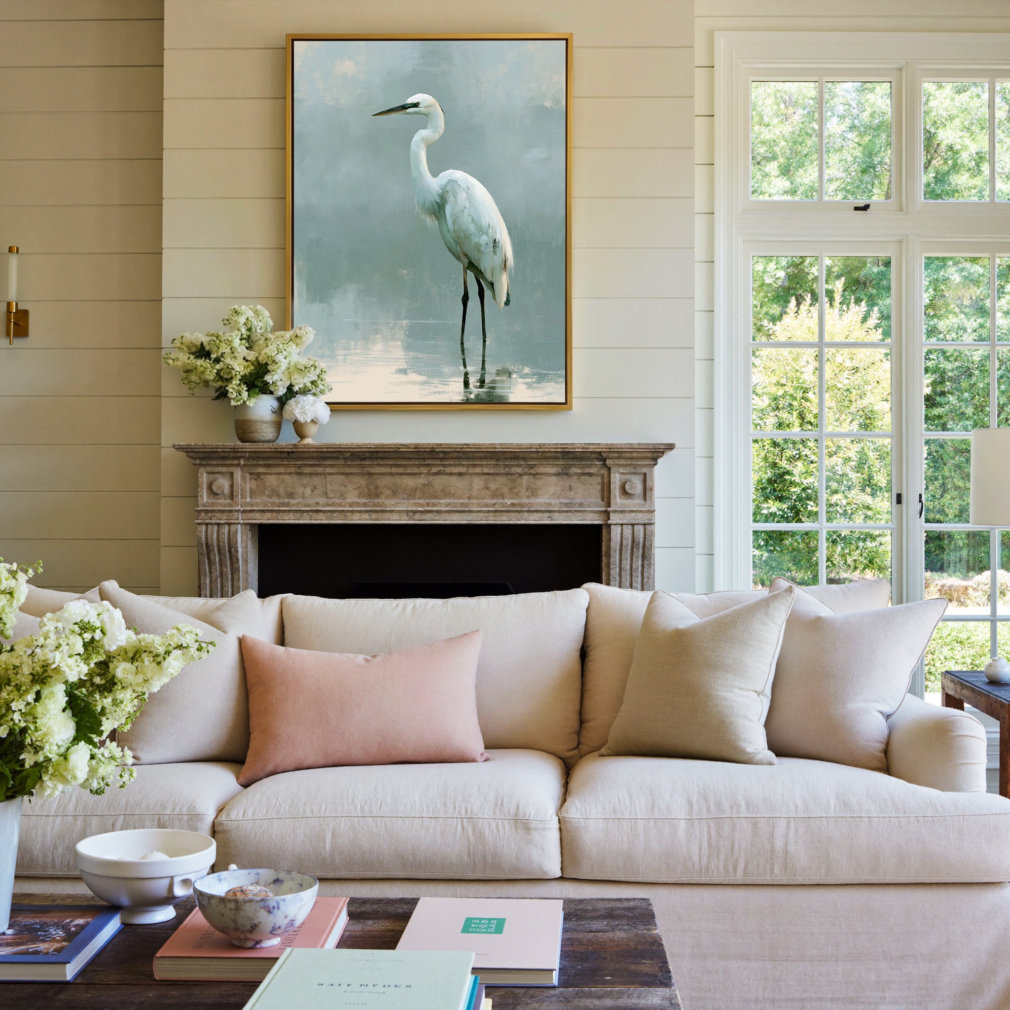 white heron in pale reflective water canvas wall art in a gold frame above a mantel