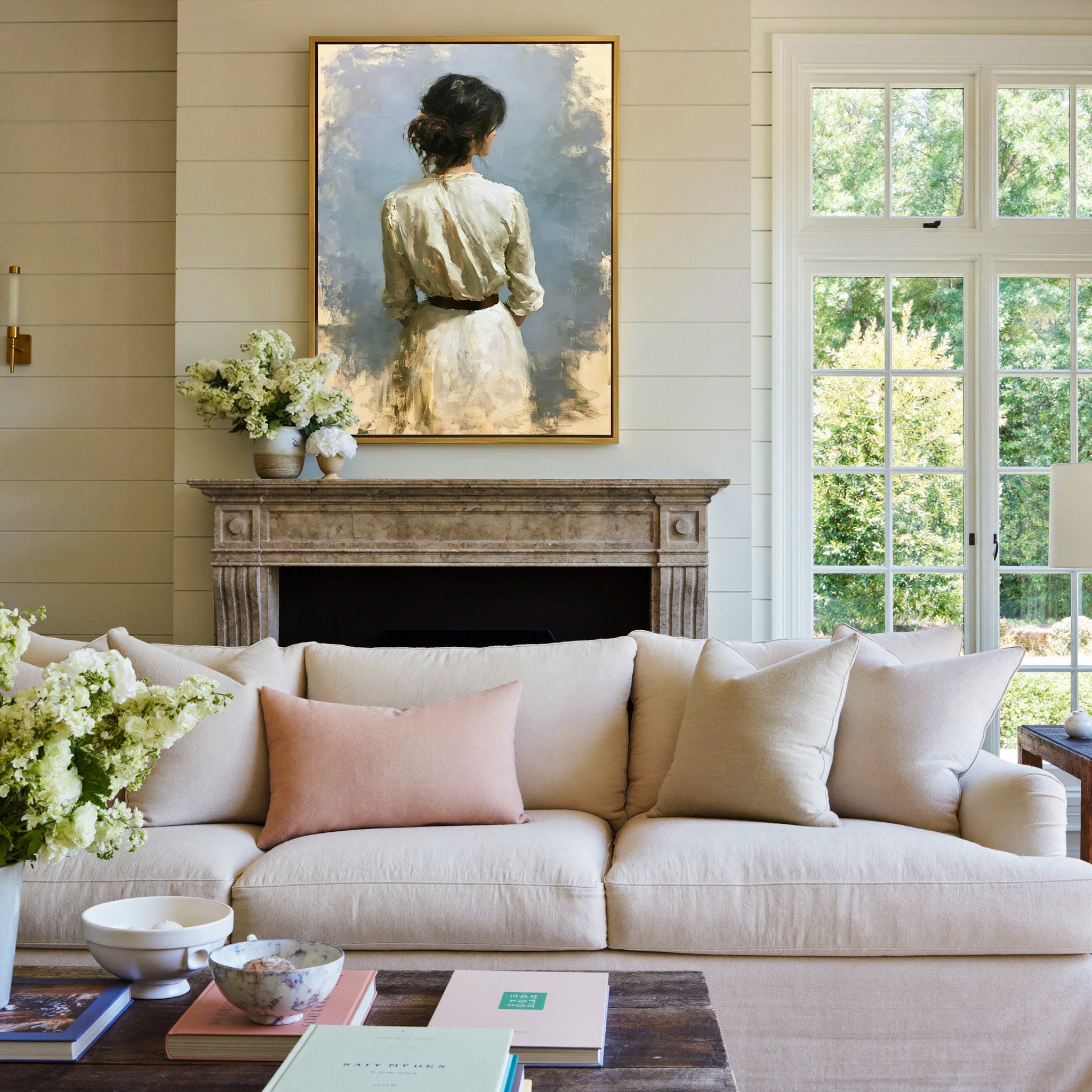 rear view woman in a white dress against a soft canvas wall art in a gold frame above a mantel