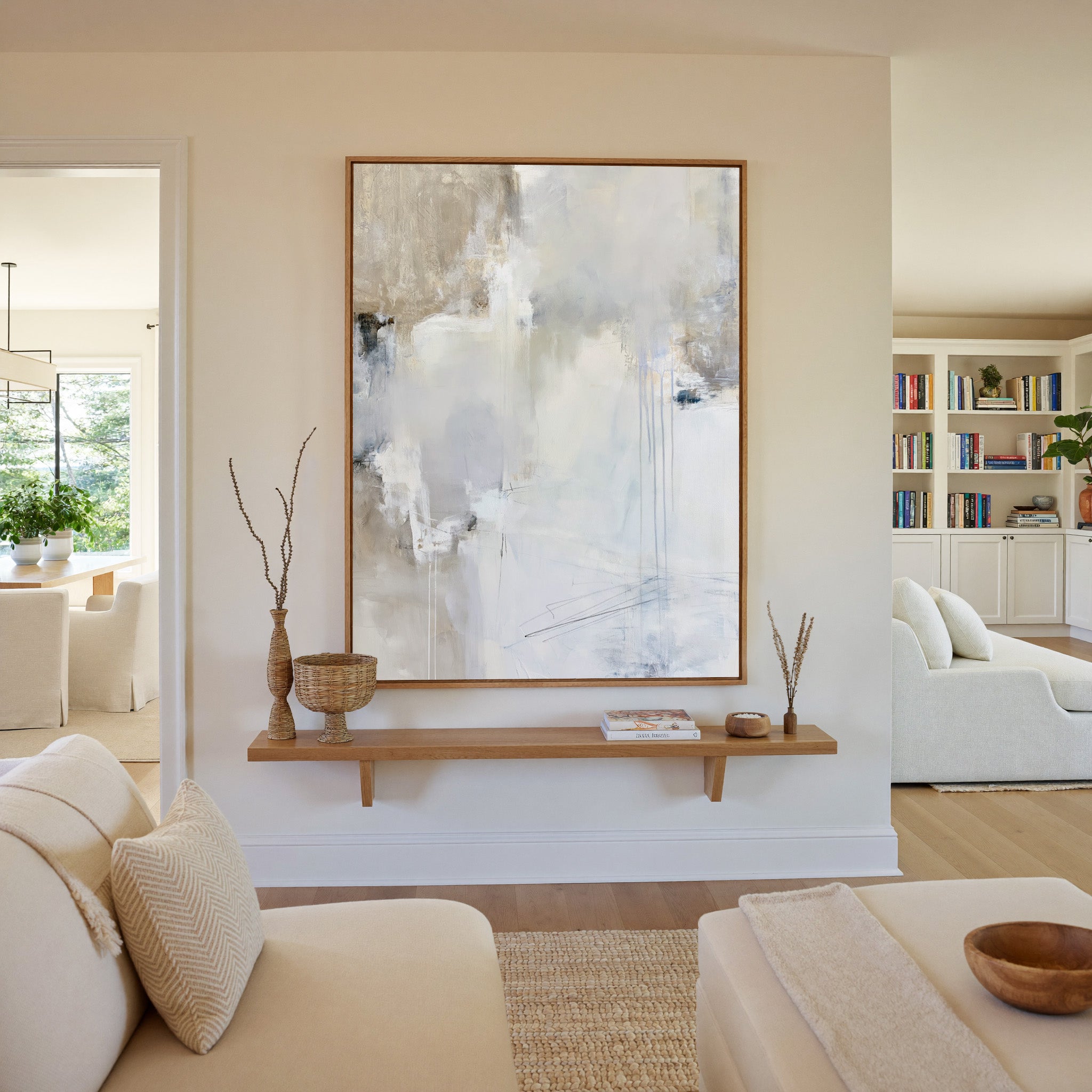 soft white and beige abstract with pale blue canvas wall art in an oak frame in a living room