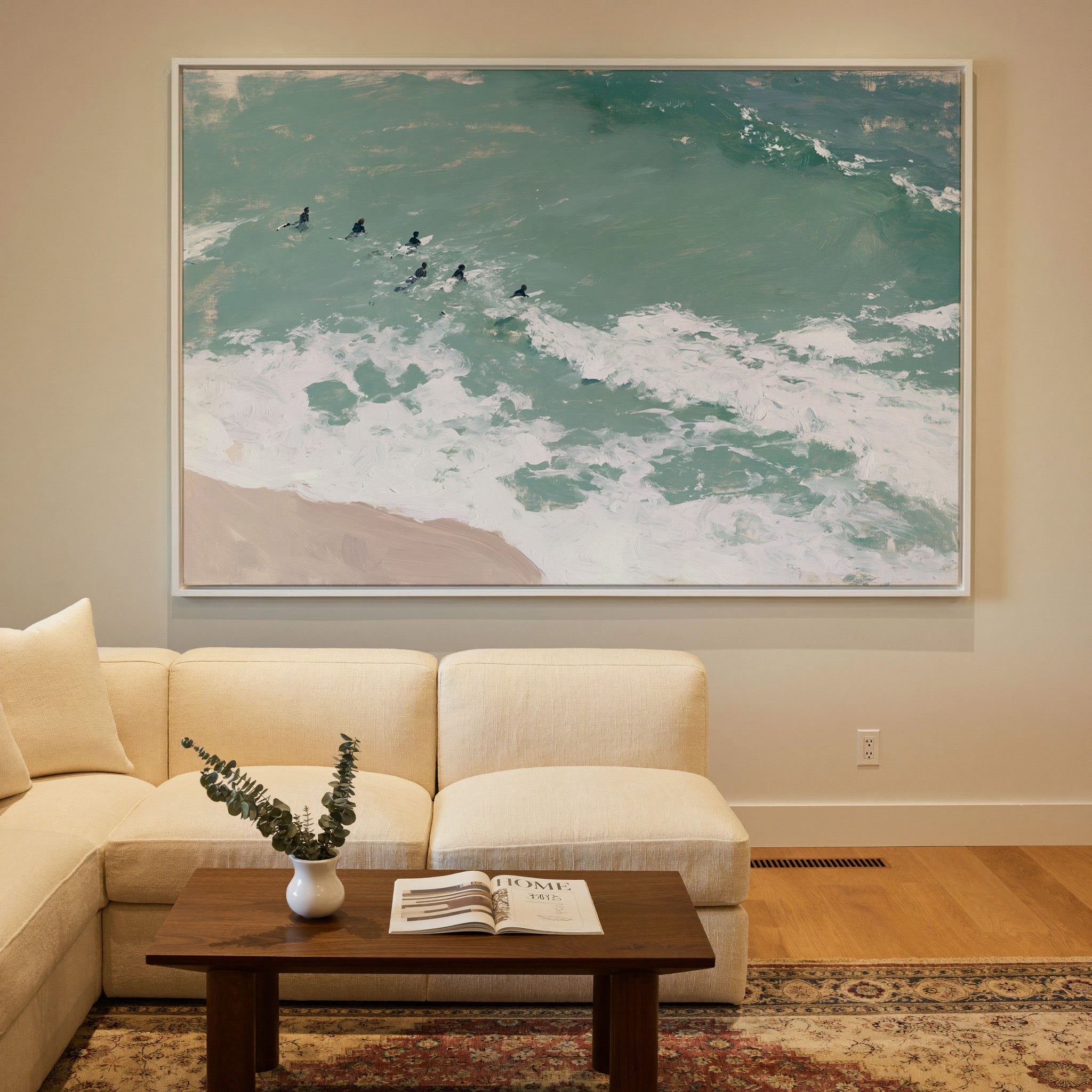 turquoise surf with small figures beyond the canvas wall art in a white frame in a styled room setting