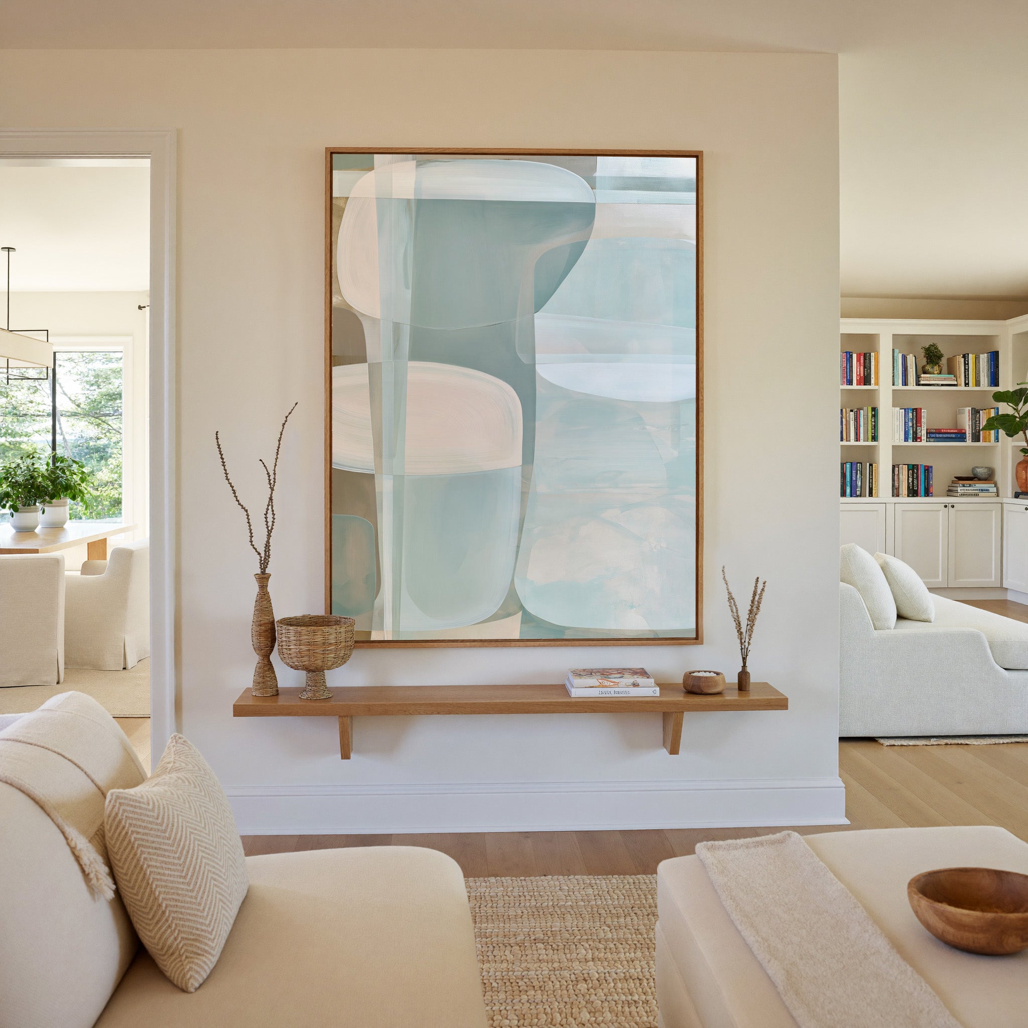 soft blue and beige abstract with rounded canvas wall art in an oak frame in a living room