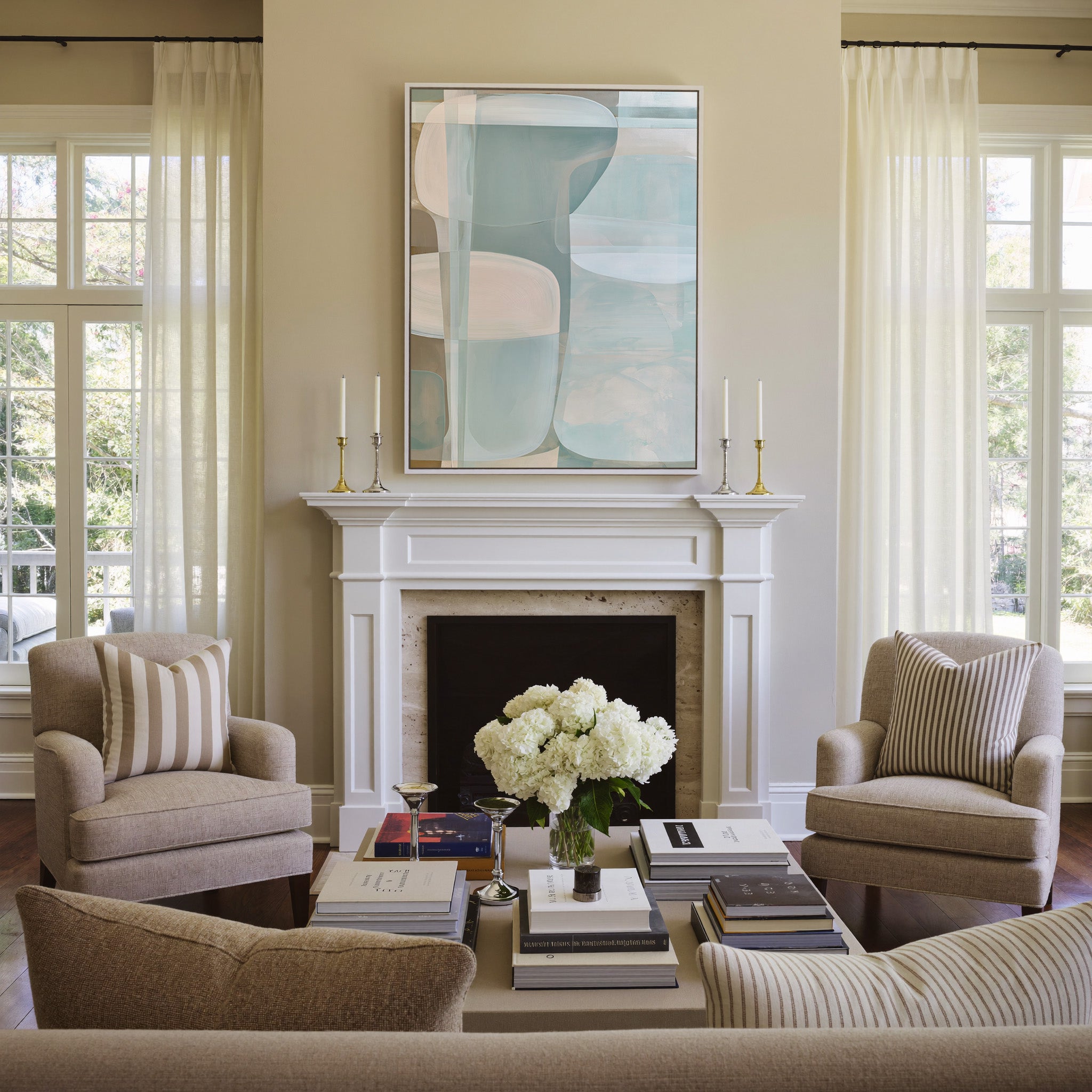 soft blue and beige abstract with rounded canvas wall art in a white frame above a mantel