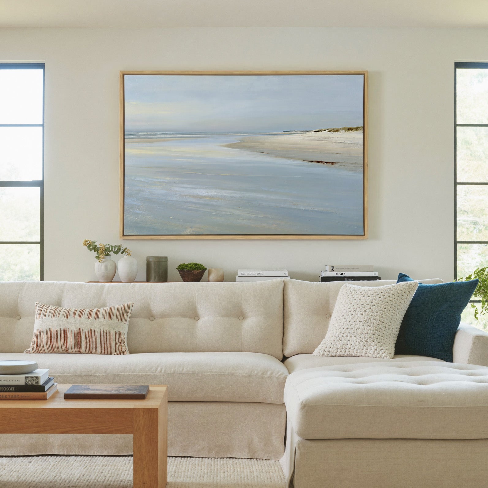 pale shoreline with wet sand and a low horizon canvas wall art in a natural wood frame in a living room