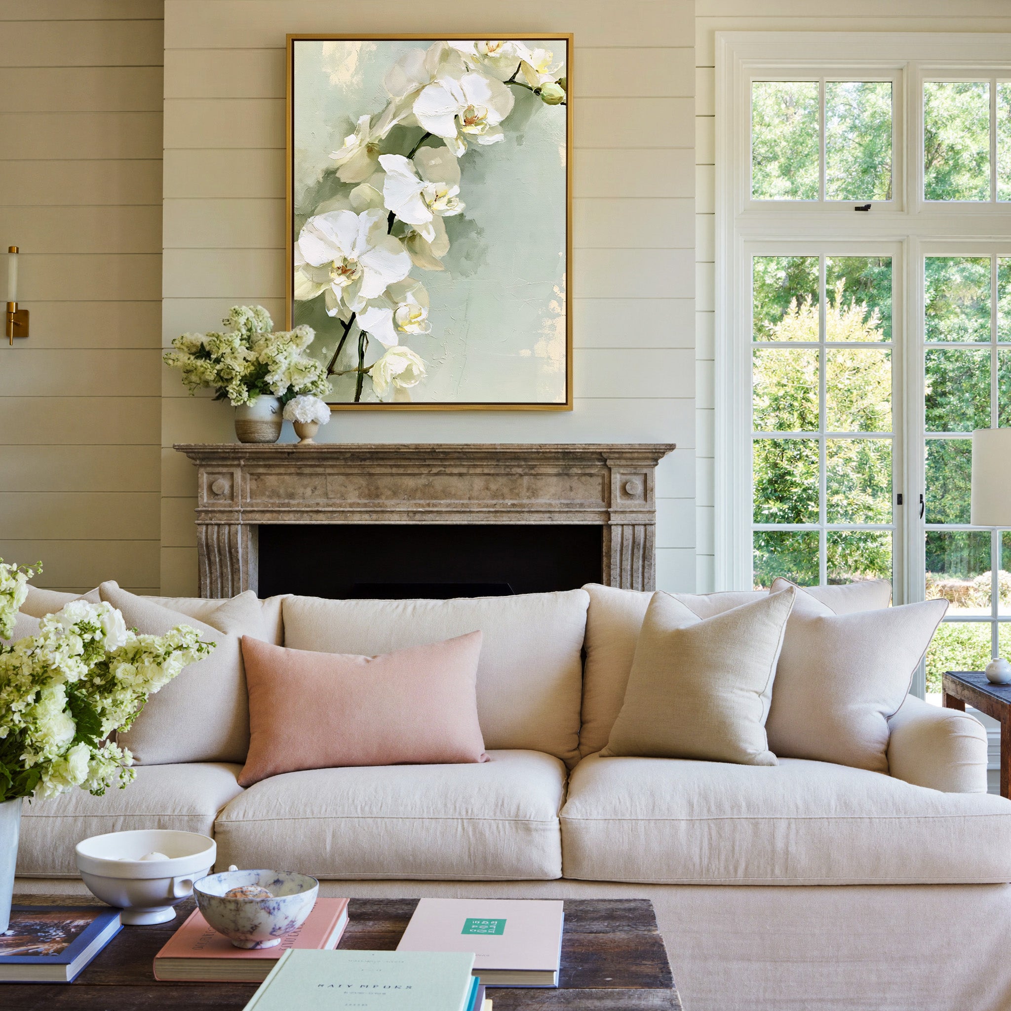 white orchids with long stems on a pale green canvas wall art in a gold frame above a mantel