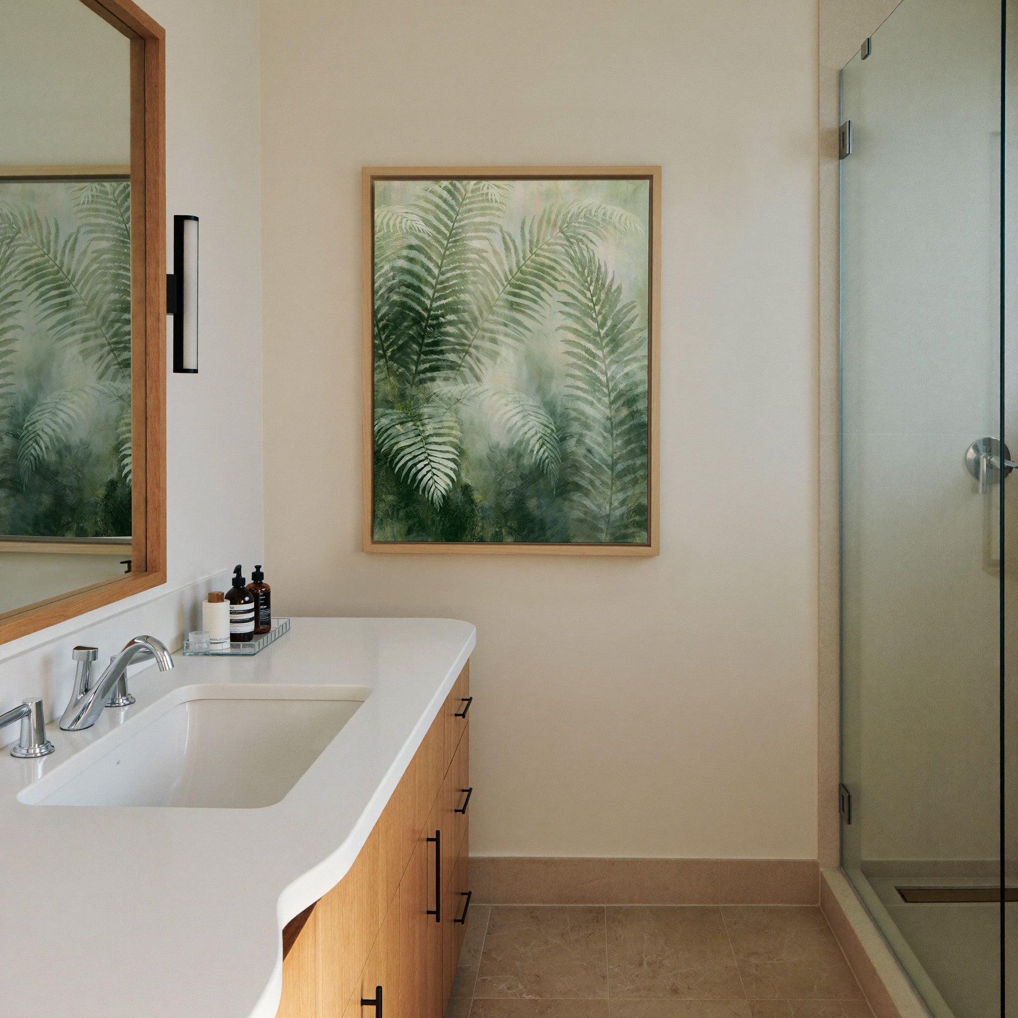 soft green fern fronds over a canvas wall art in a natural wood frame in a styled room setting