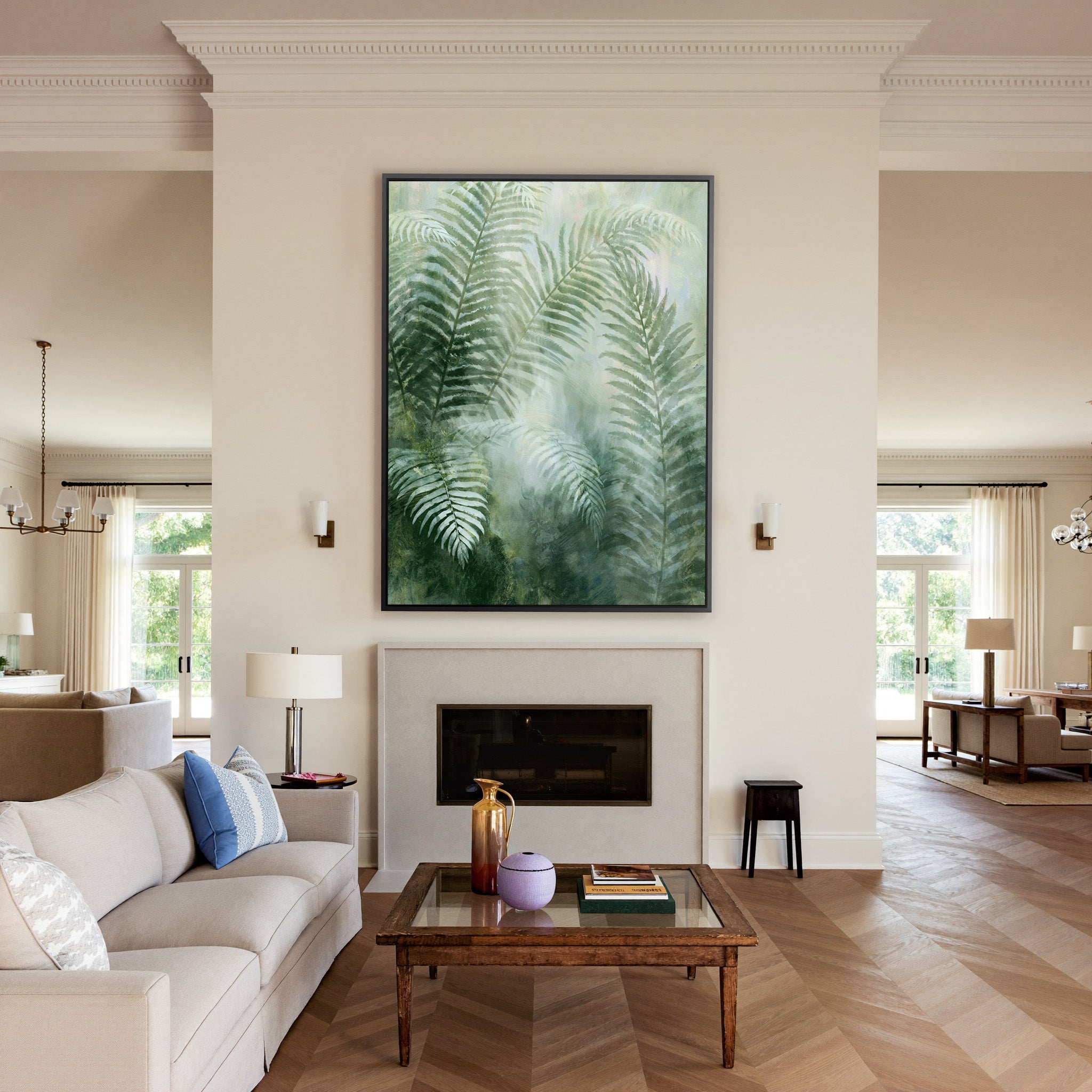 soft green fern fronds over a misty pale ground canvas wall art in a black frame above a mantel