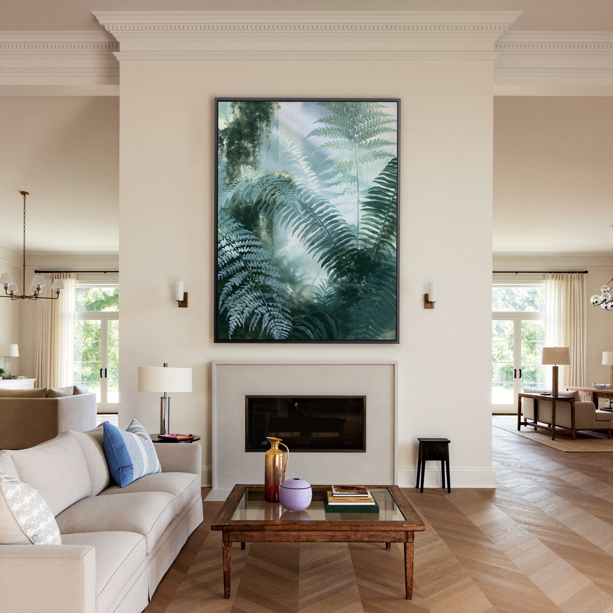 soft green fern fronds over a misted blue gray canvas wall art in a black frame above a mantel