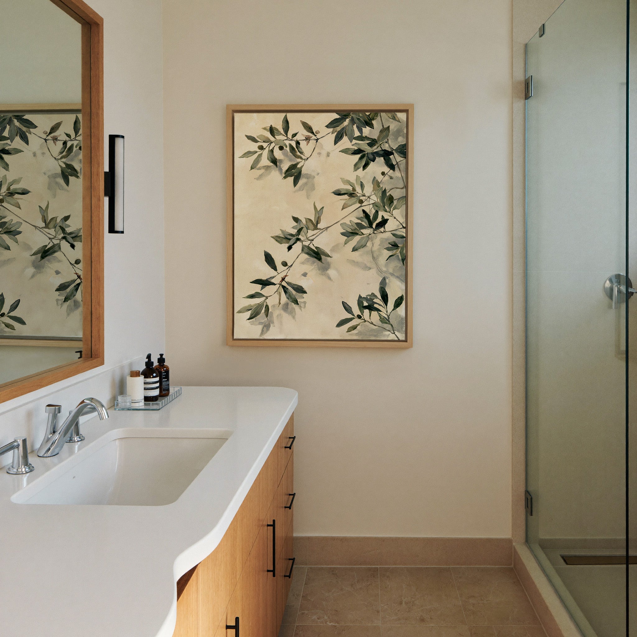 olive branches with soft sage and deep green canvas wall art in a natural wood frame in a styled room setting