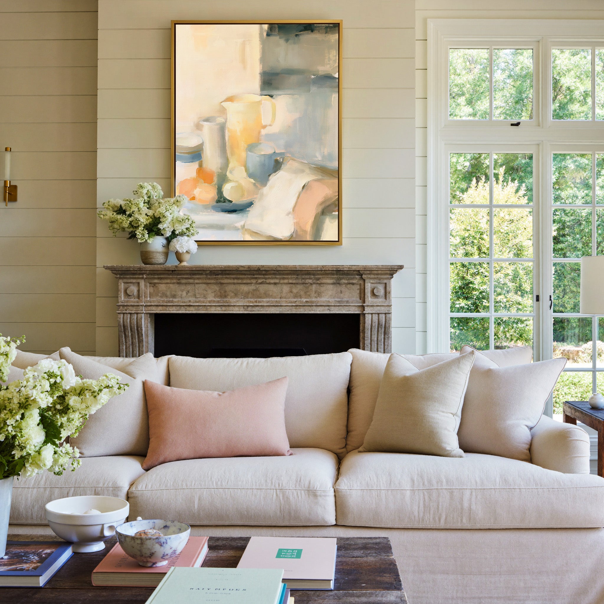soft neutral still life with pitcher, cups, and canvas wall art in a gold frame above a mantel