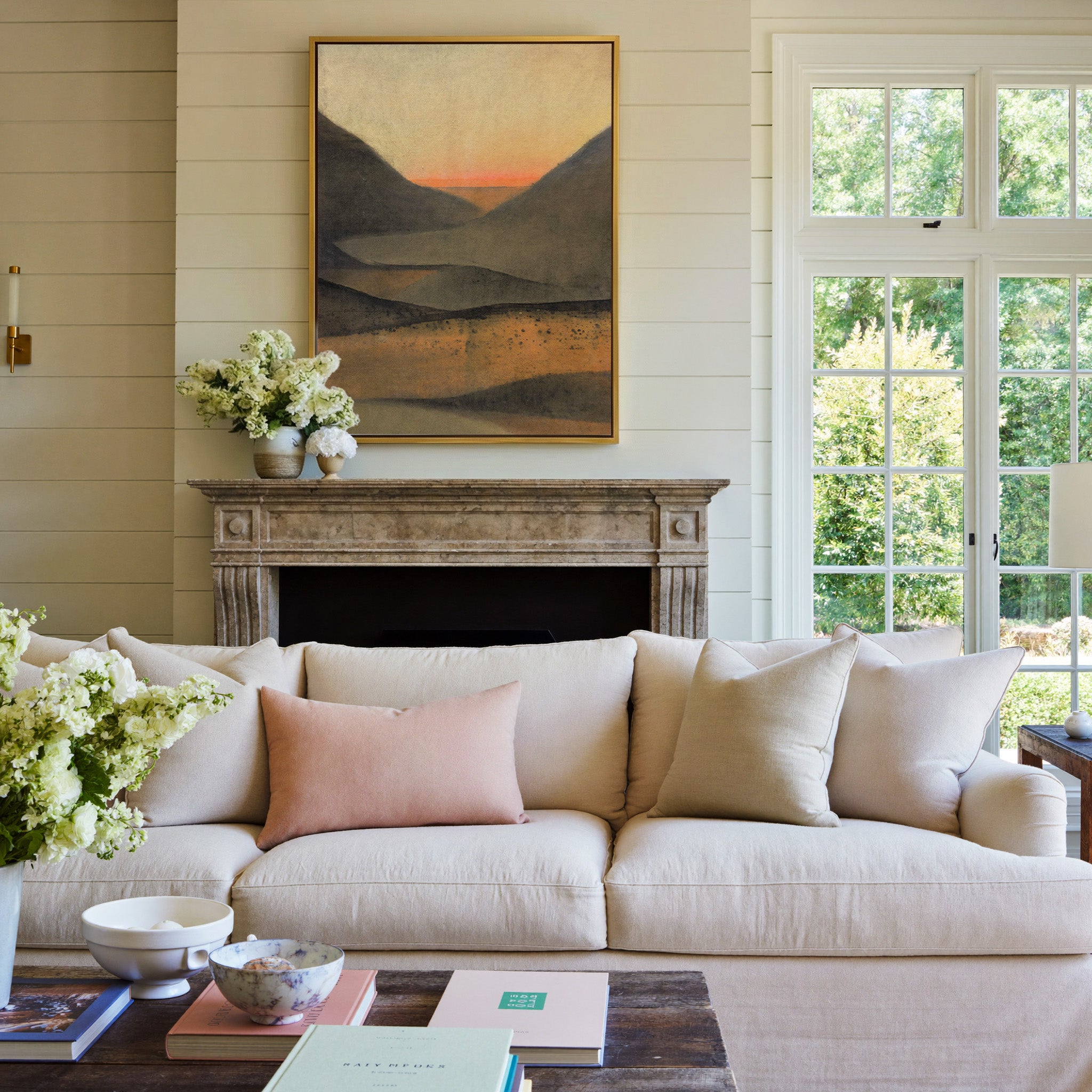dark mountain landscape with a narrow orange canvas wall art in a gold frame above a mantel