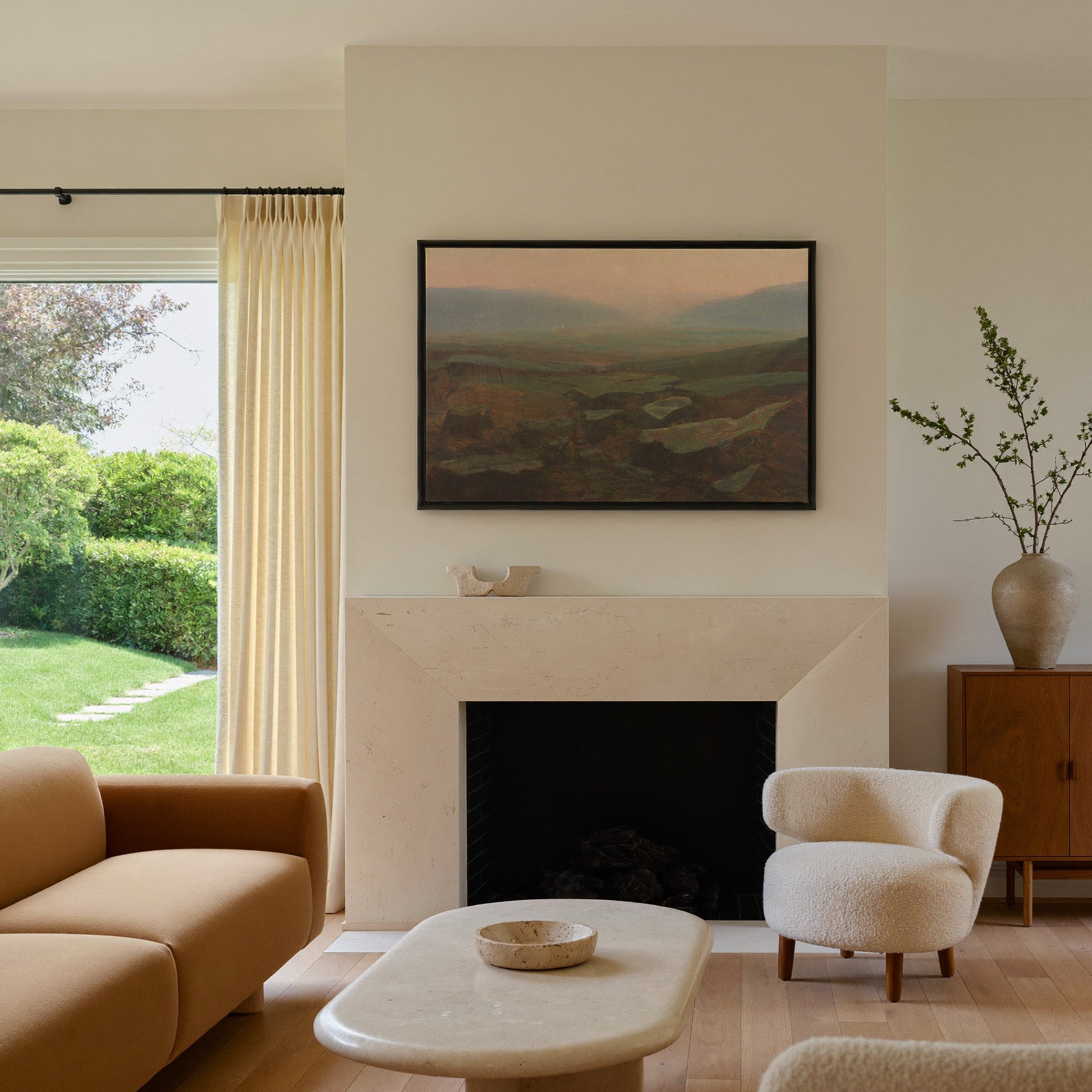 soft canyon landscape with layered mesas and a canvas wall art in a black frame above a mantel