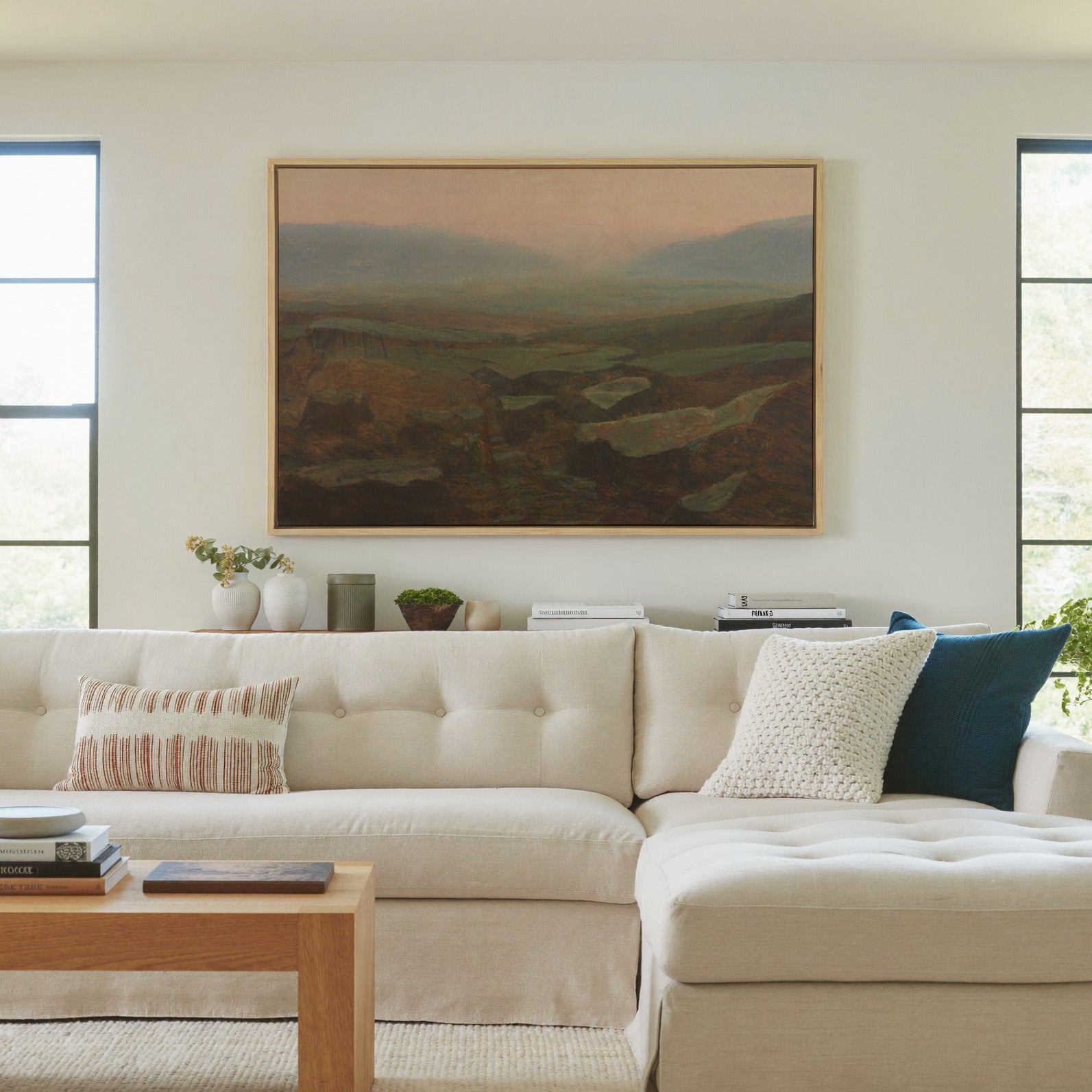 soft canyon landscape with layered mesas and a canvas wall art in a natural wood frame in a living room