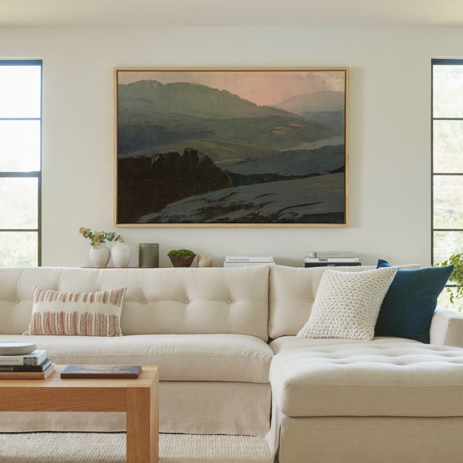 misty mountain landscape with dark foreground canvas wall art in a natural wood frame in a living room