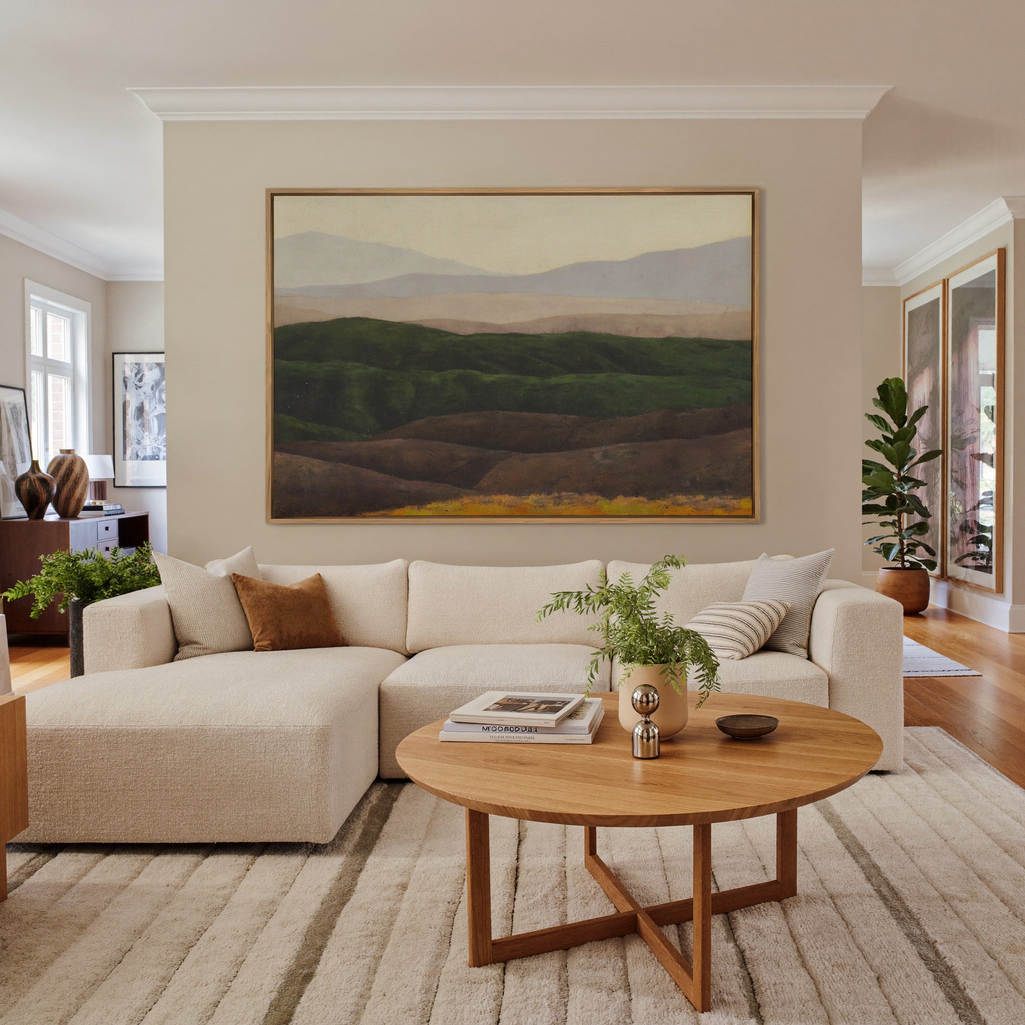 layered green hills with pale distant mountains canvas wall art in an oak frame in a living room