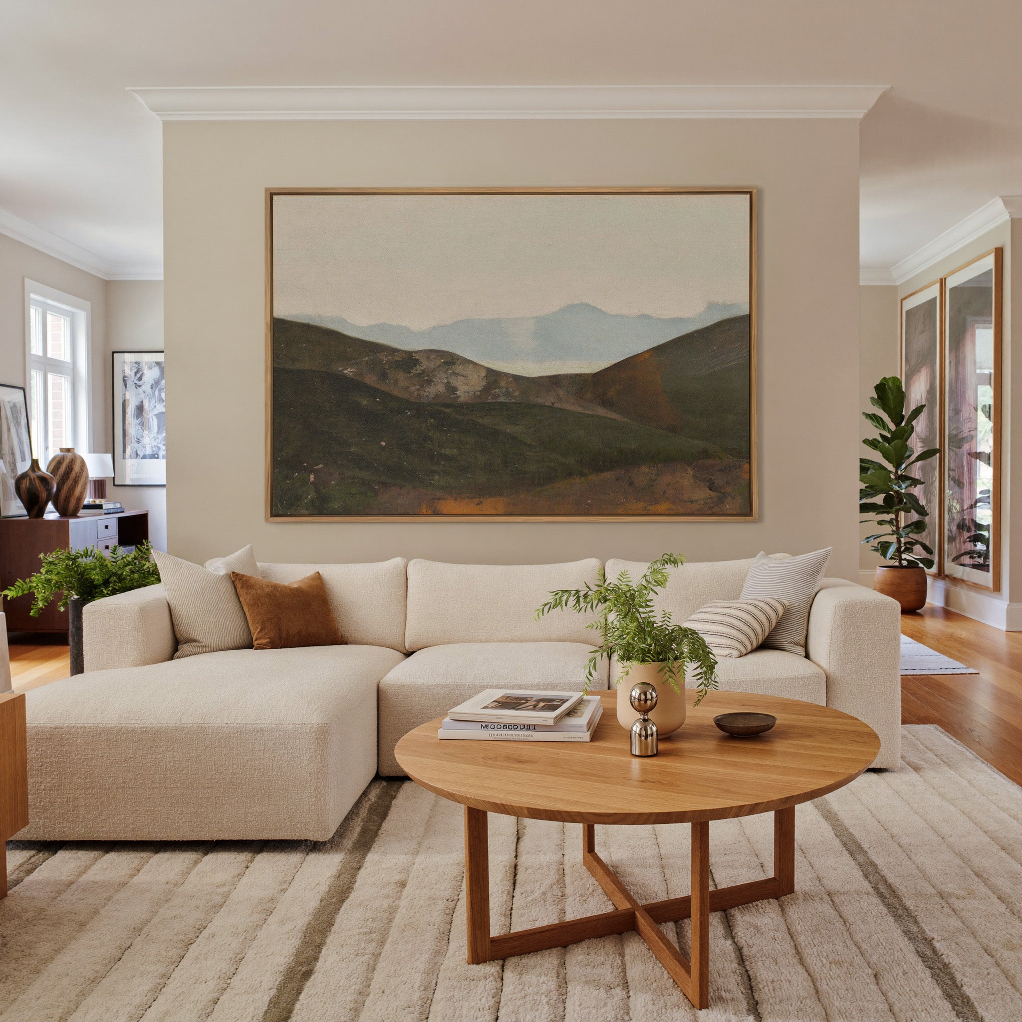 soft blue mountain landscape with dark canvas wall art in an oak frame in a living room