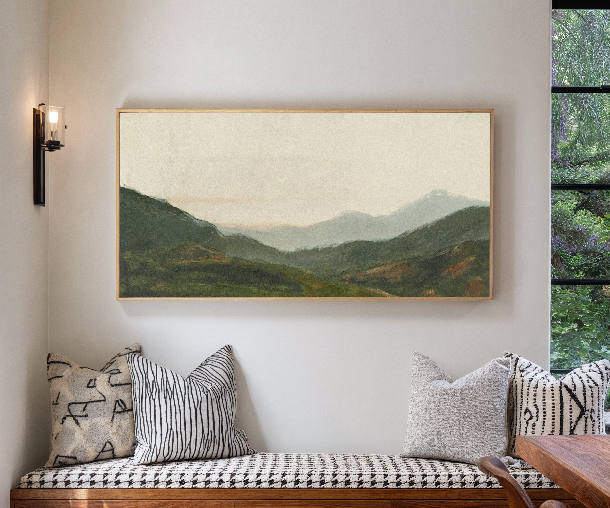 misty green mountain landscape canvas wall art in a natural wood frame in a living room