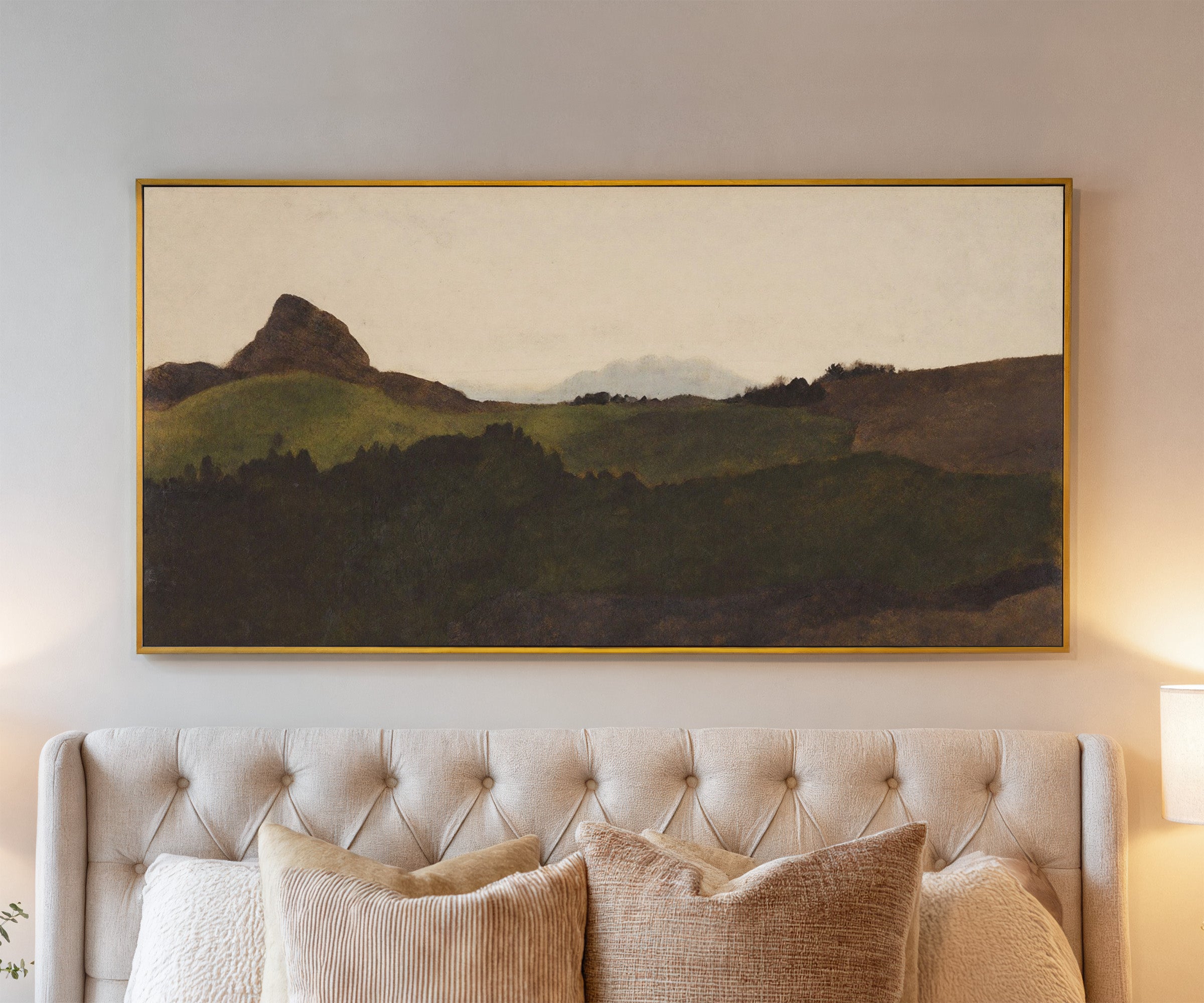 dark green hills with a pale distant peak canvas wall art in a gold frame above a bed