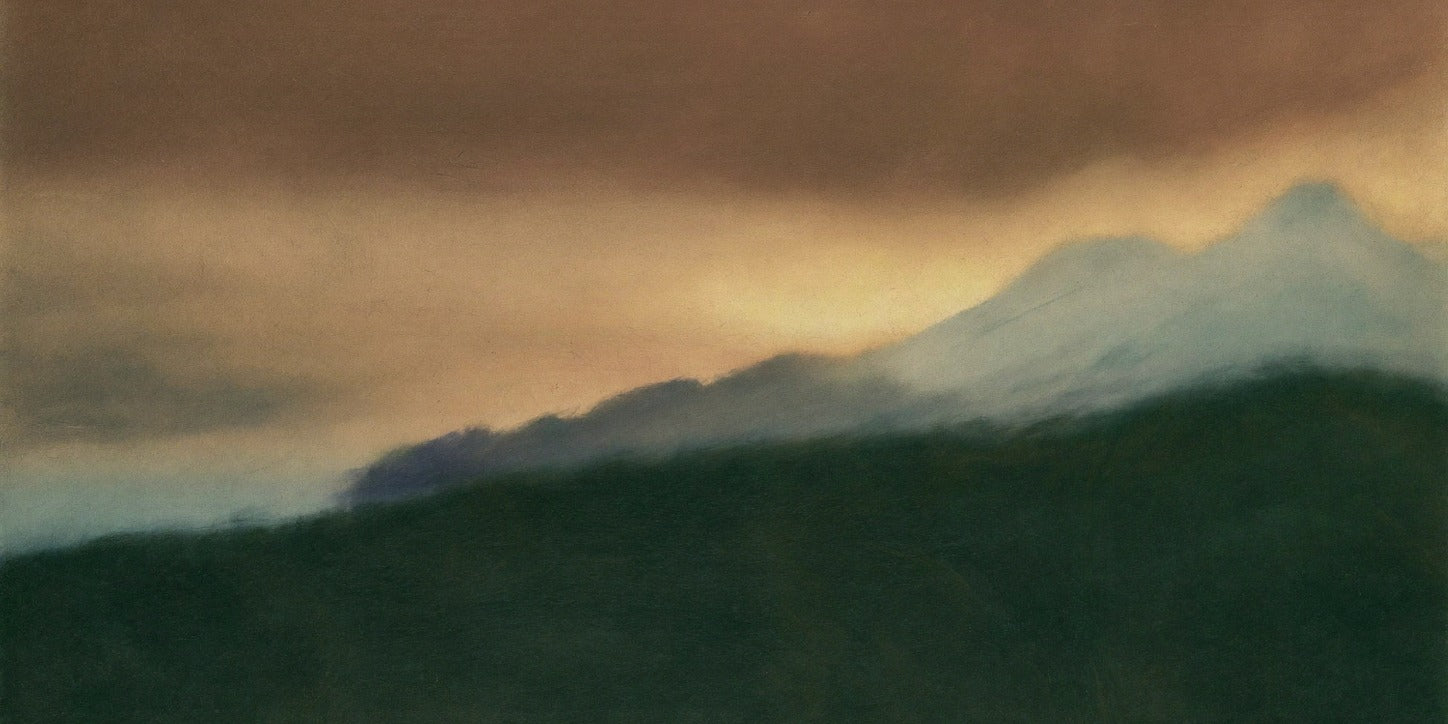 Dark green slopes below pale blue peaks under a warm gold and brown clouded sky