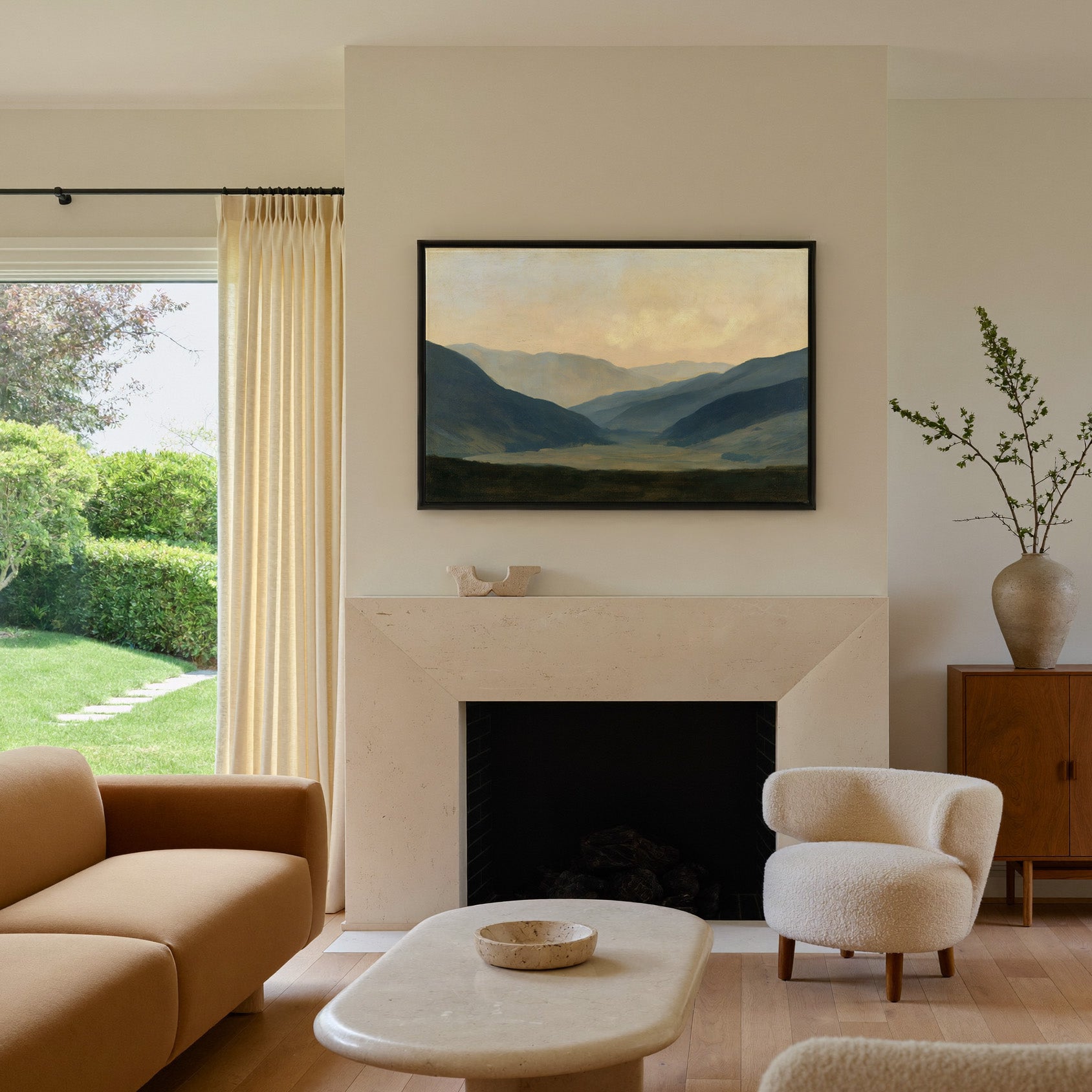 soft blue mountain valley at dawn canvas wall art in a black frame above a mantel