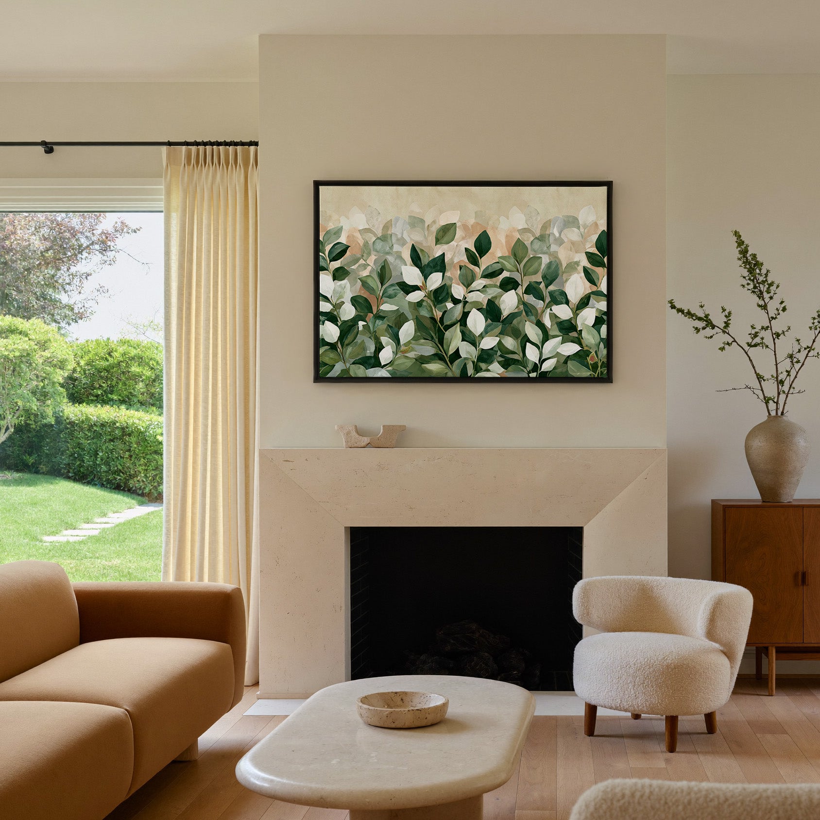 overlapping green and cream leaves canvas wall art in a black frame above a mantel