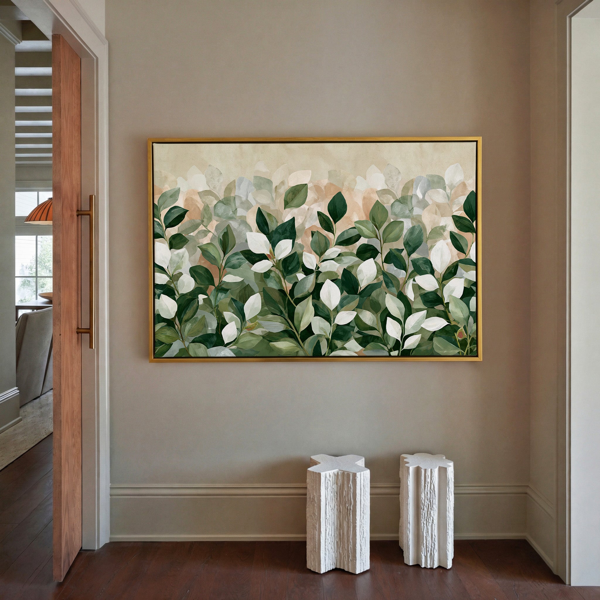 overlapping green and cream leaves canvas wall art in a gold frame in a styled room setting