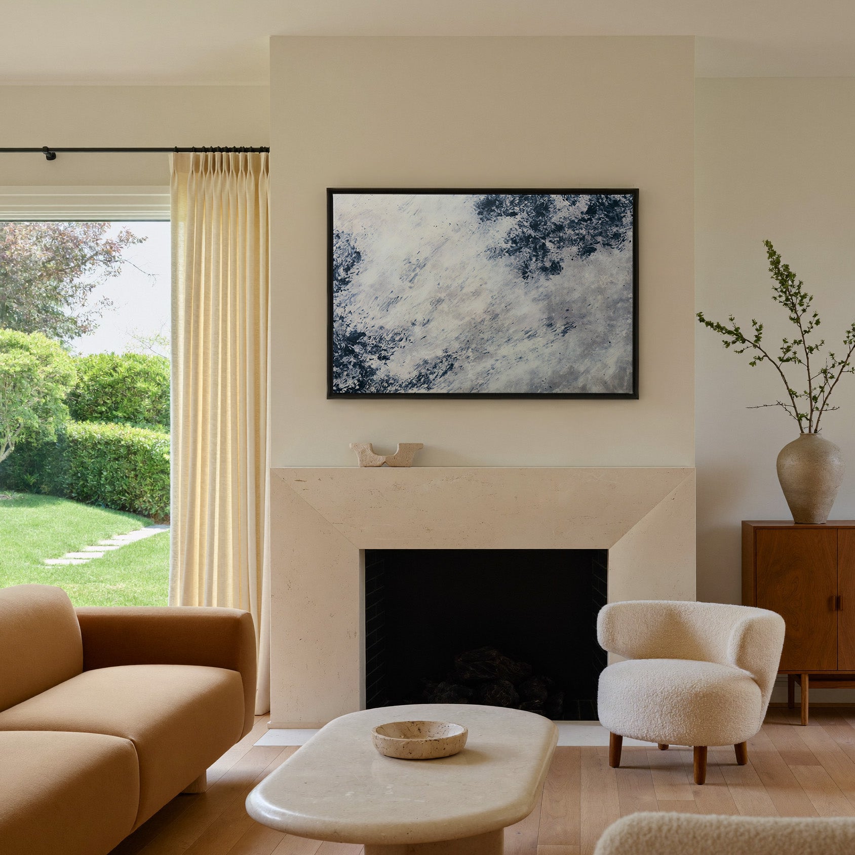 soft black and blue abstract with scattered canvas wall art in a black frame above a mantel